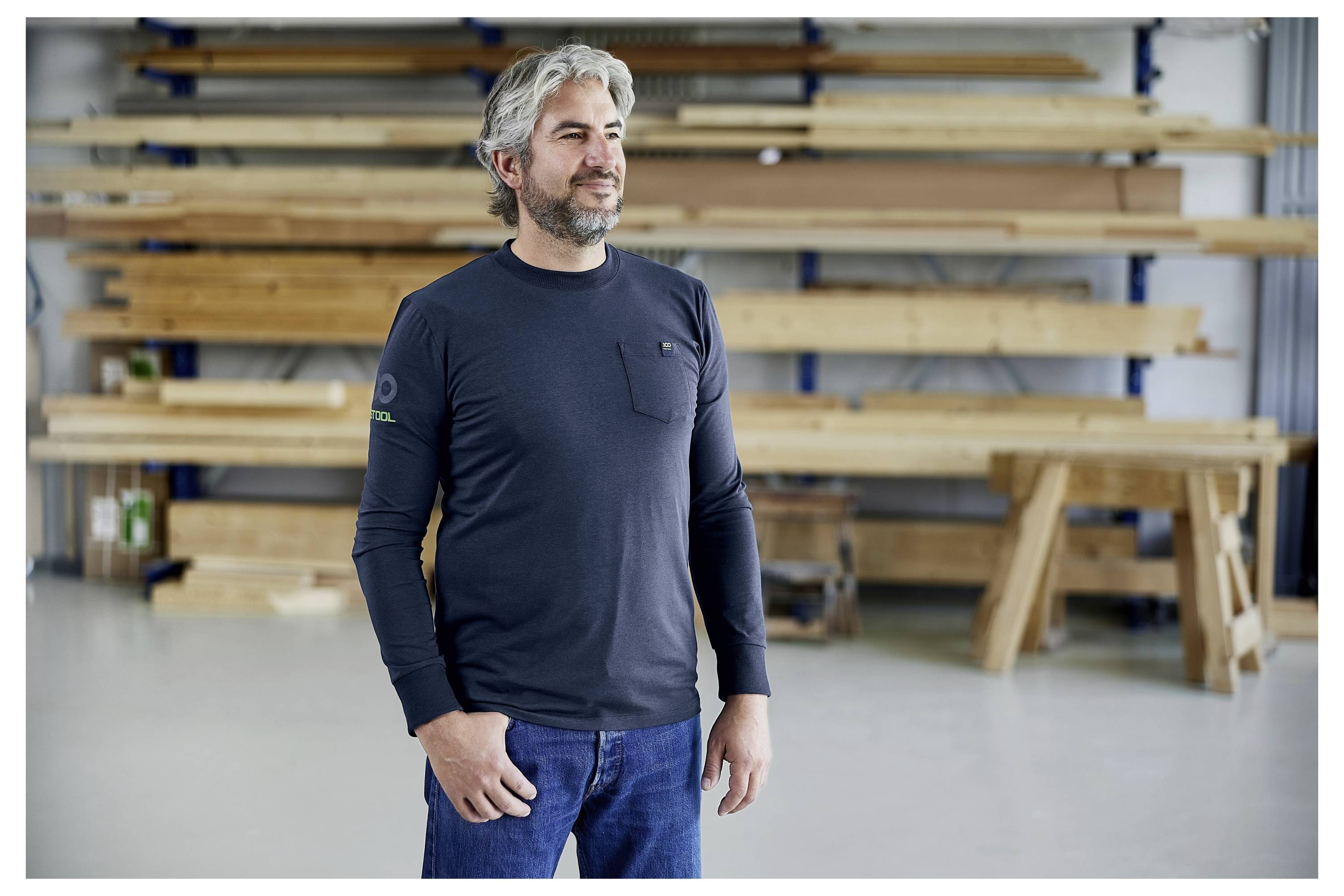 Eine offene kleine Kunststoff-Organisatorbox mit Fächern, die verschiedene Metall- und Kunststofffastener enthält, auf einer Pegboard-Oberfläche platziert.