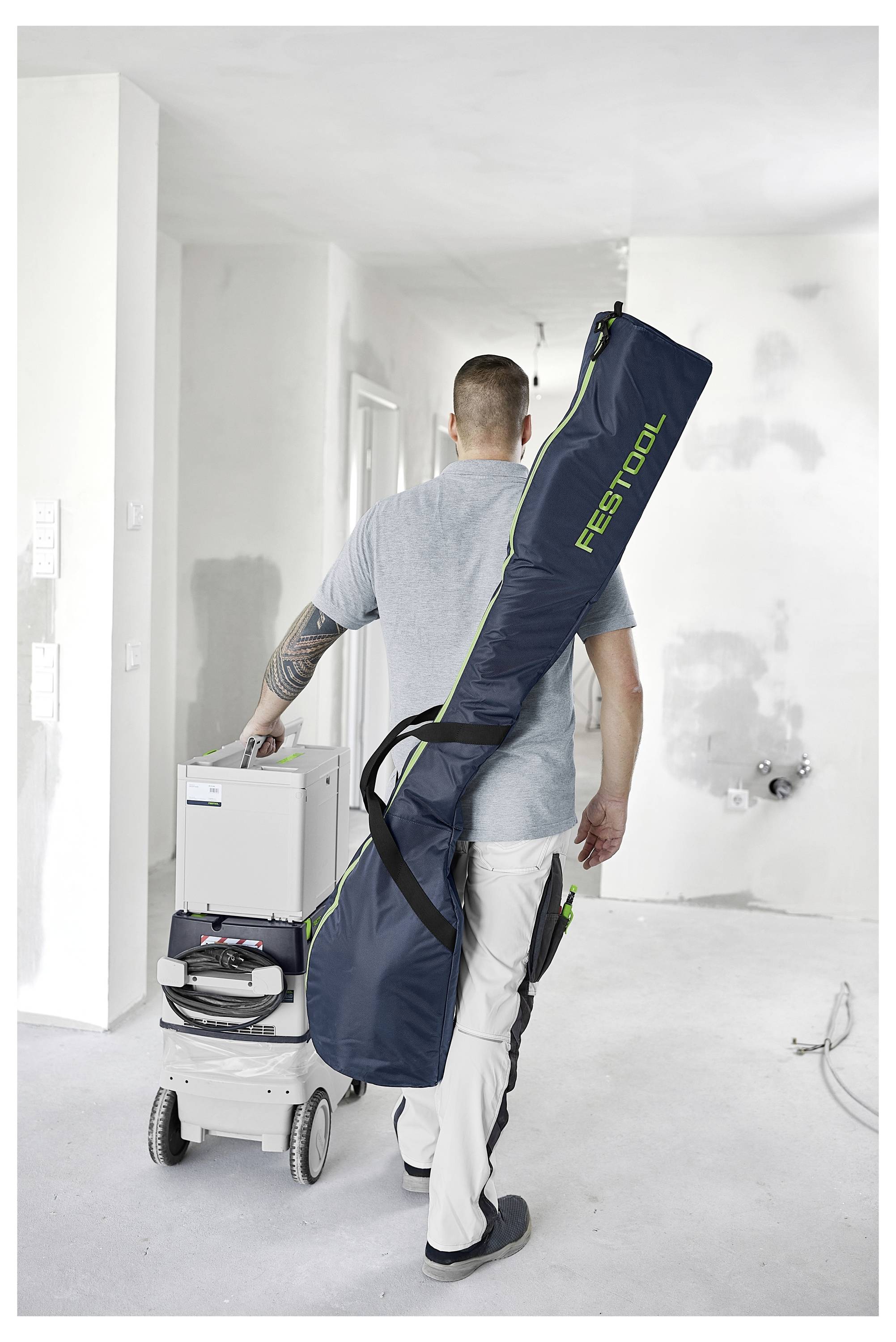 Hände halten einen Festool RO 125 FEQ Schleiffer und glätten eine weiße Oberflächenkante.