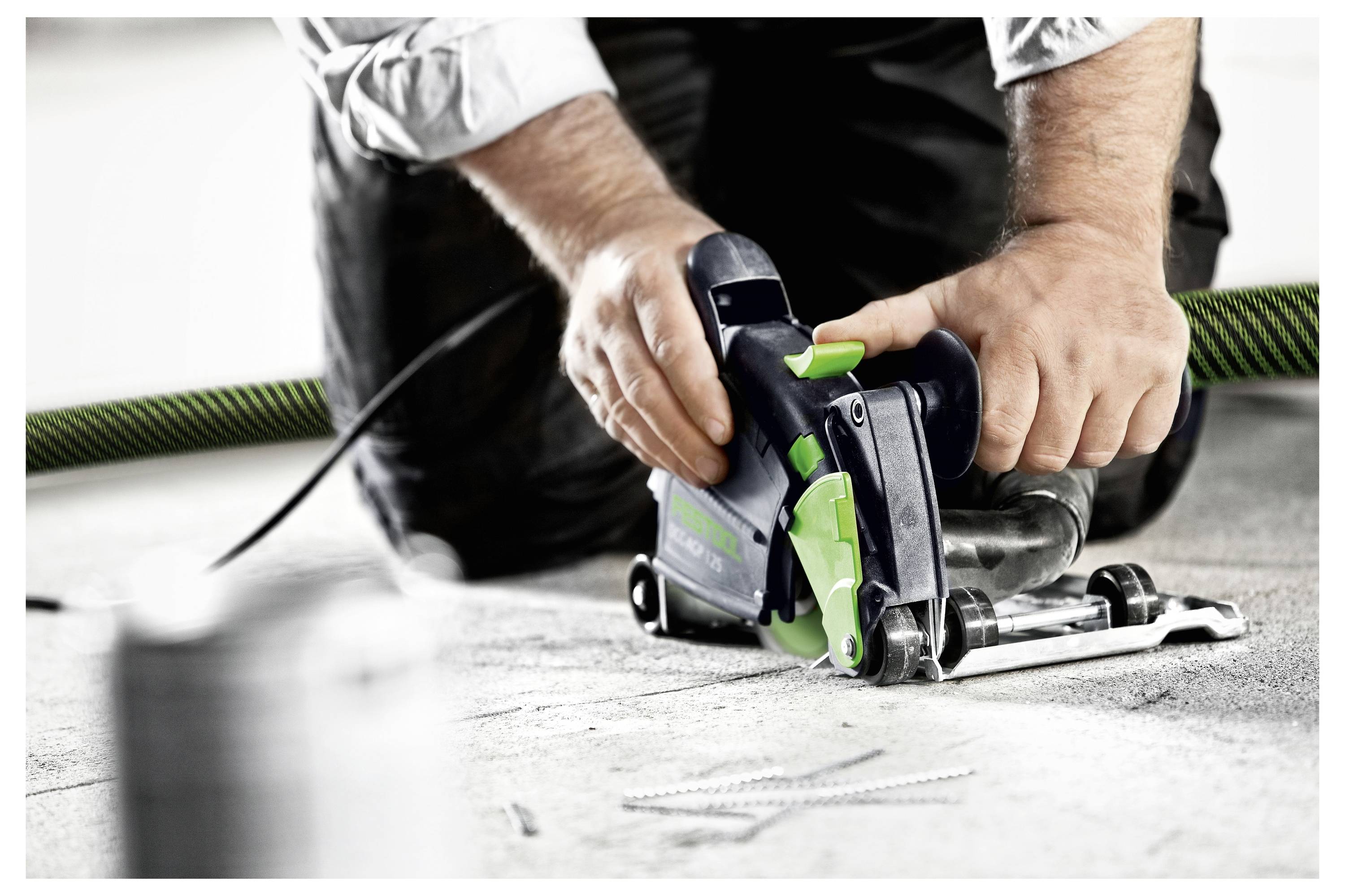 Ein Mann, der einen Vakuumverschließer auf einem Tisch in einem hellen Raum benutzt, trägt ein zwangloses graues Hemd und eine Brille, mit Regalen im Hintergrund.