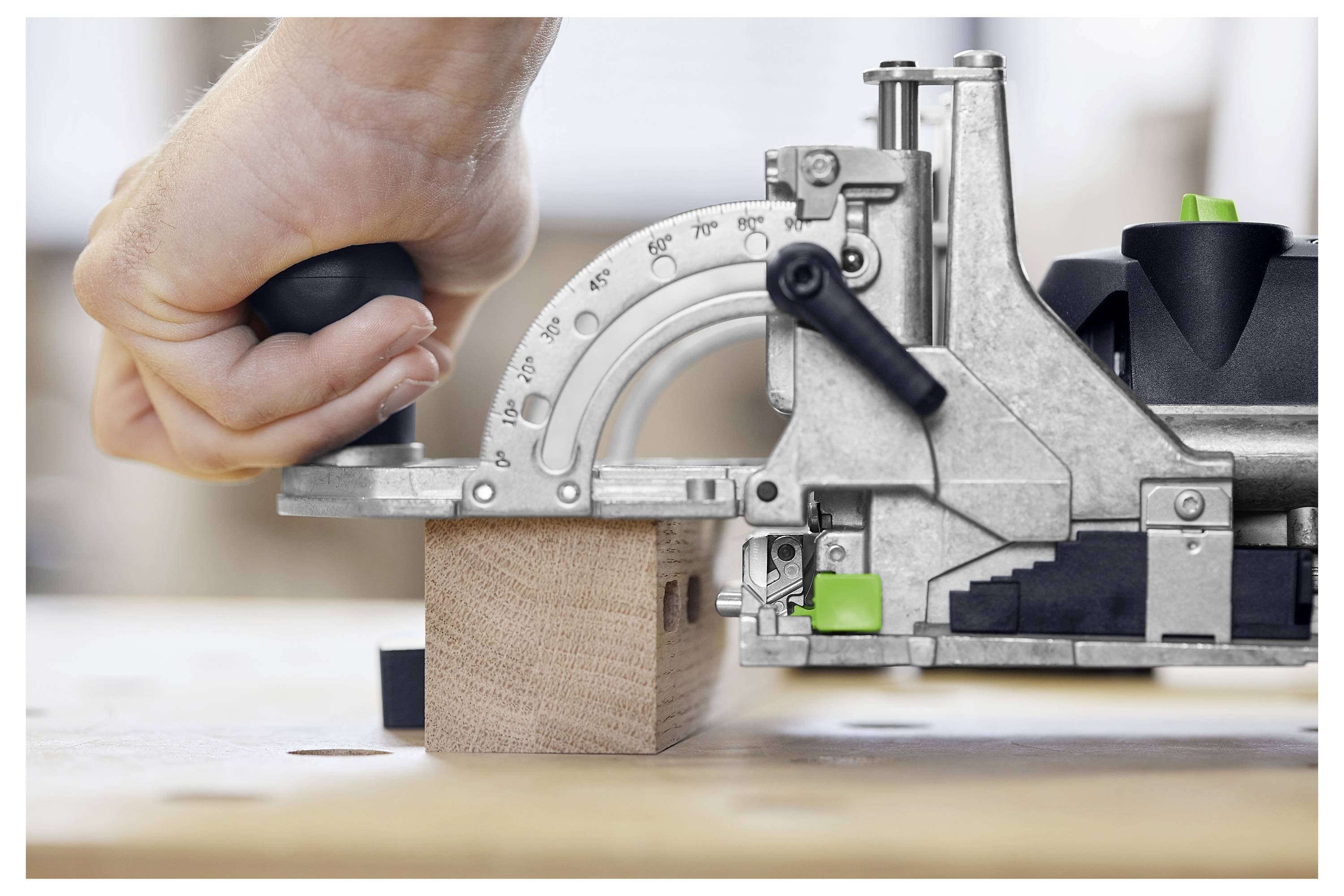 Eine Person in einer Baustelle nutzt ein Elektrowerkzeug, um an einer Holzwand zu arbeiten, während sie einen Exoskelett-Anzug zur Unterstützung trägt.