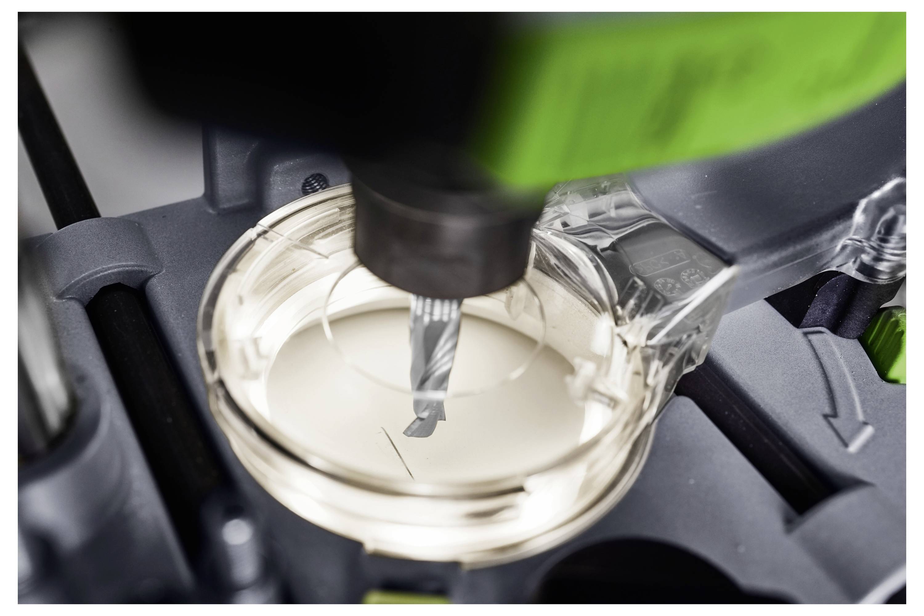 Eine schwarz-grüne Festool Akku-Säge mit transparenter Schutzvorrichtung für das Sägeblatt, die ein Festool-Logo und einen 18V-Akku zeigt, seitlich ausgerichtet.