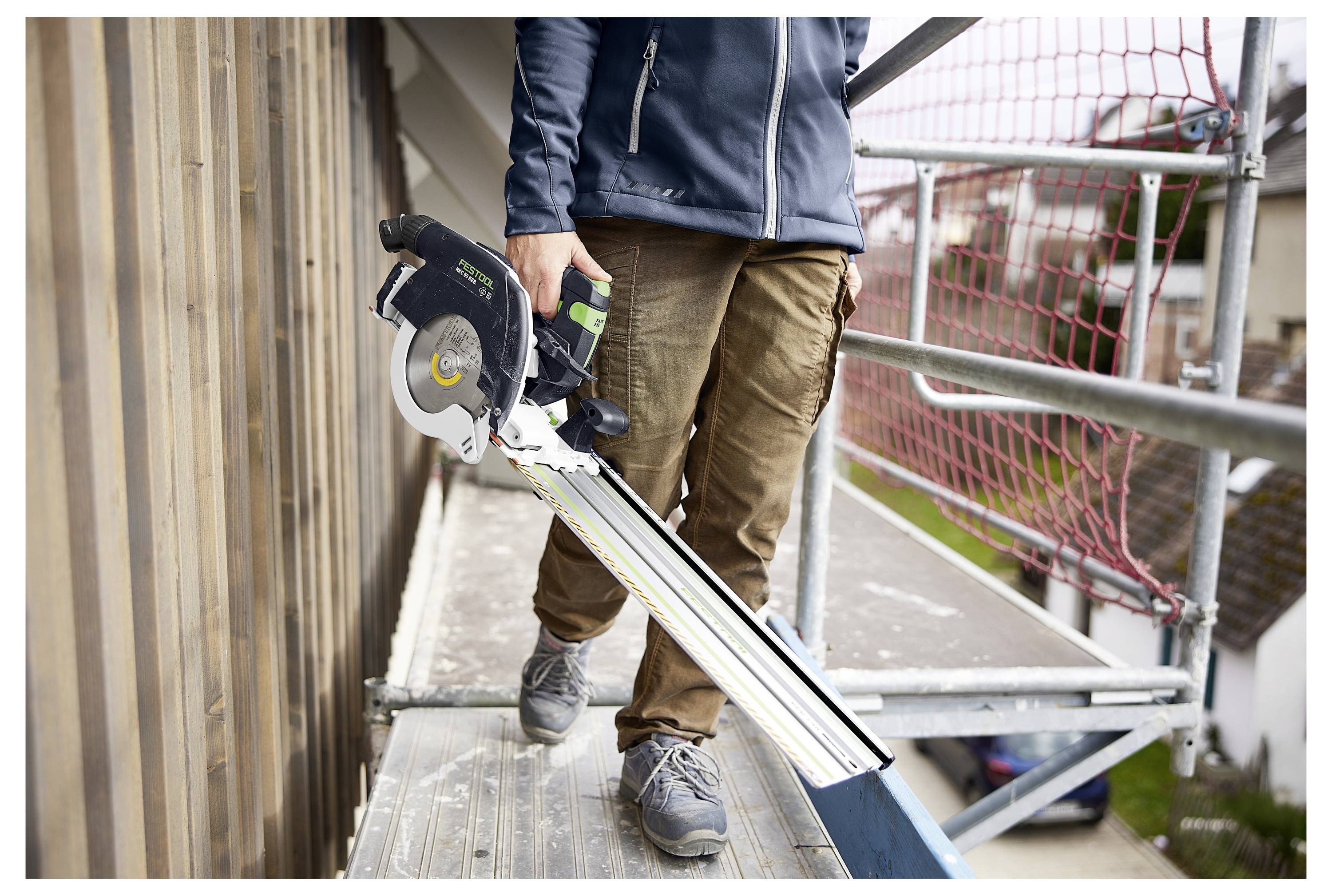 Ein Festool KA 65 Kantenleimgerät auf einer hellfarbigen Werkbank, ausgestattet für präzise Holzbearbeitungsaufgaben, mit unscharfem grauem Hintergrund.