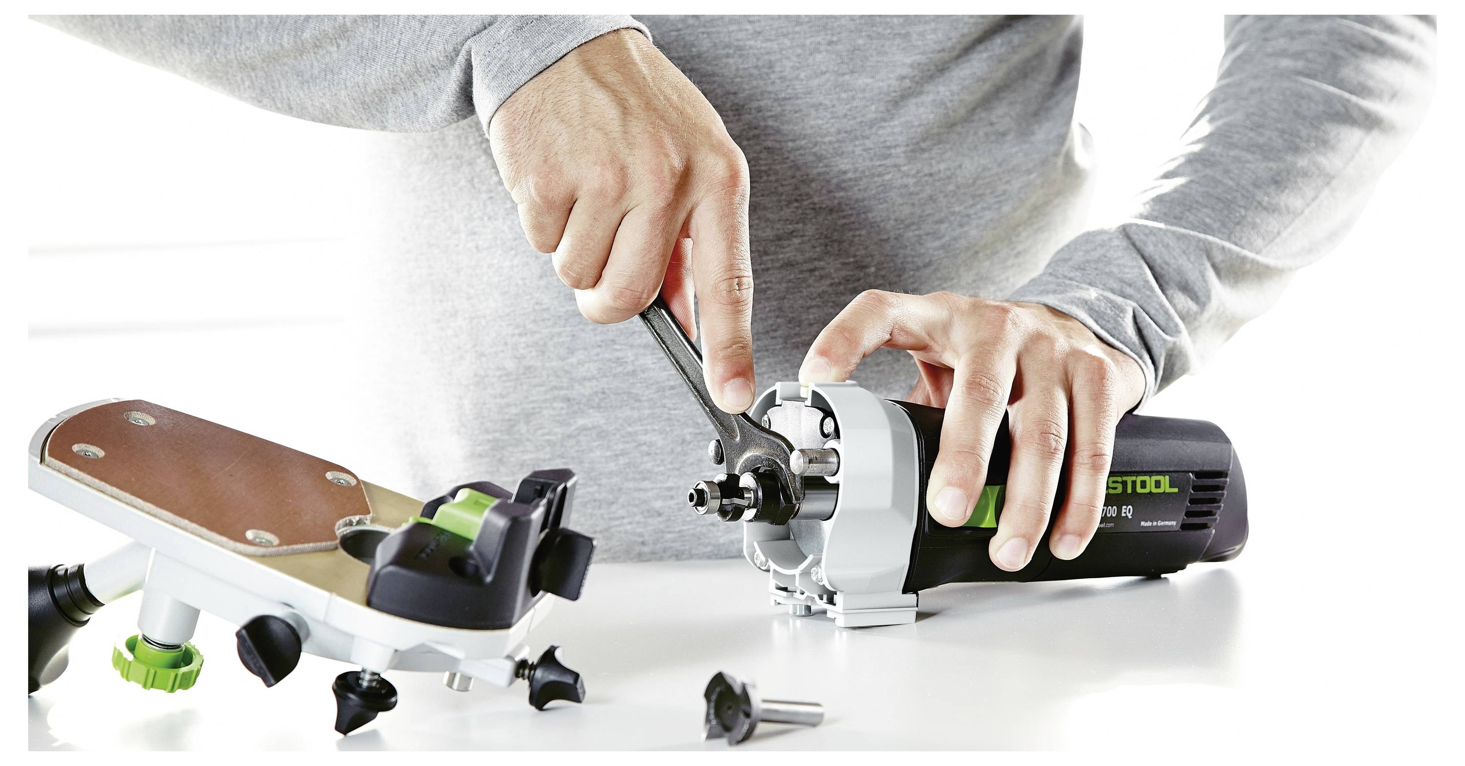 Ein Staubsauger in einem sauberen Raum, wobei eine Person mit einem Schlauchaufsatz den Boden reinigt.