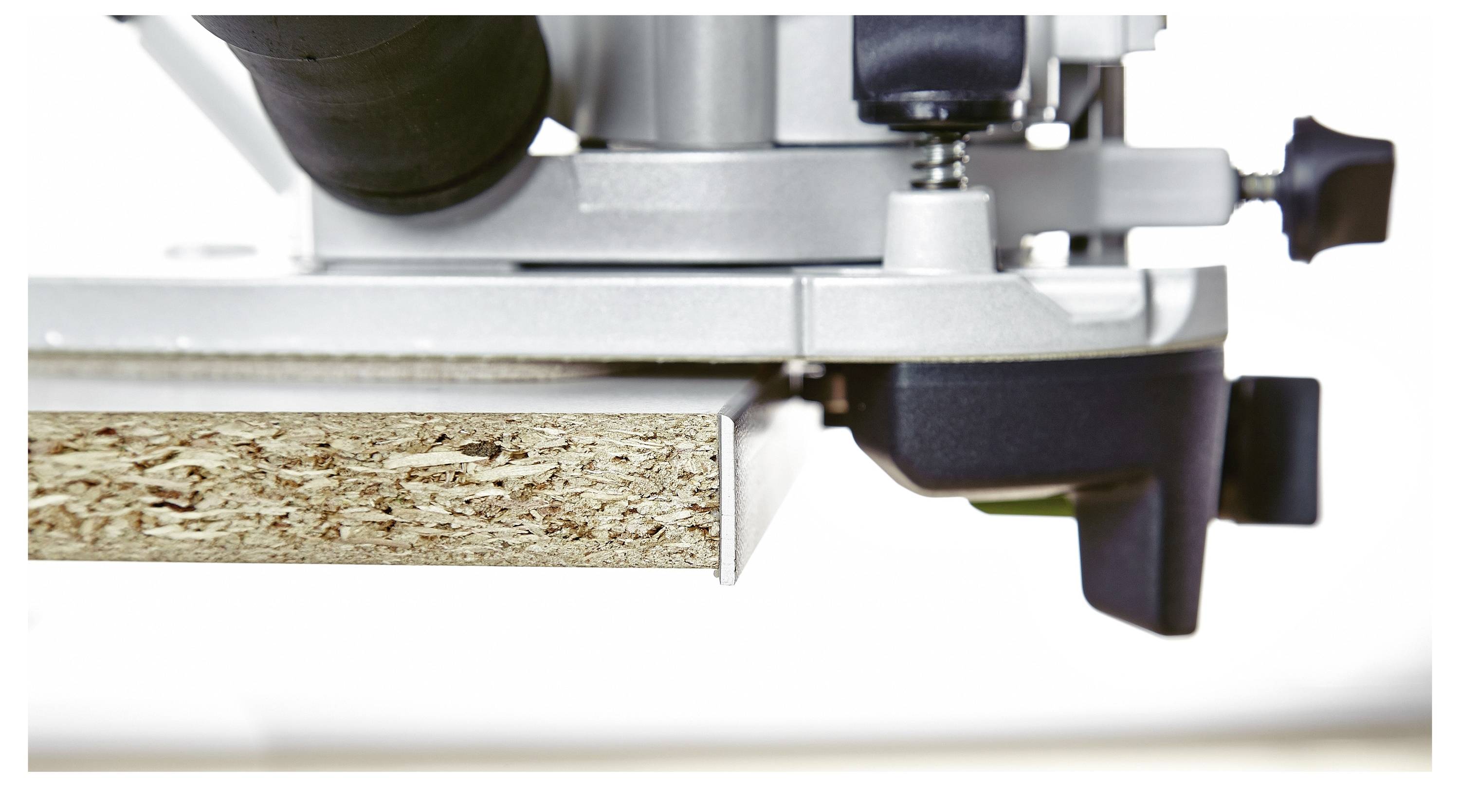 Eine Person stellt einen Staubabscheider ein, der auf einer Deckenhalterung in einer Werkstatt montiert ist. Das Gerät ist weiß mit grünen Akzenten.