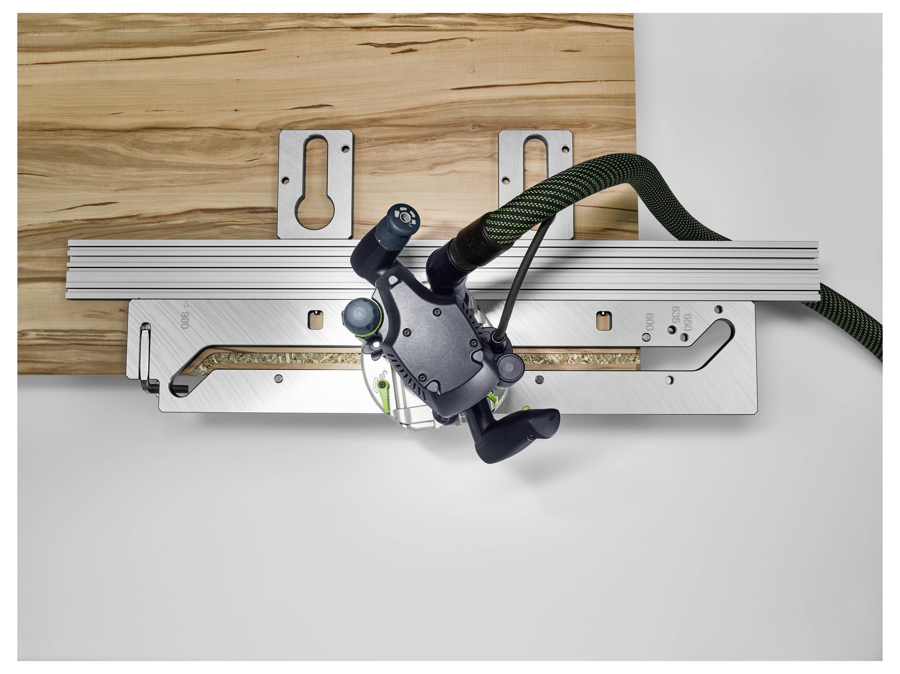 Eine Person nutzt einen elektrischen Schleiffer, um ein Holzgeländer in einer sonnigen Werkstatt zu glätten und hebt dabei Handwerkskunst und Holzbearbeitungsfähigkeiten hervor.