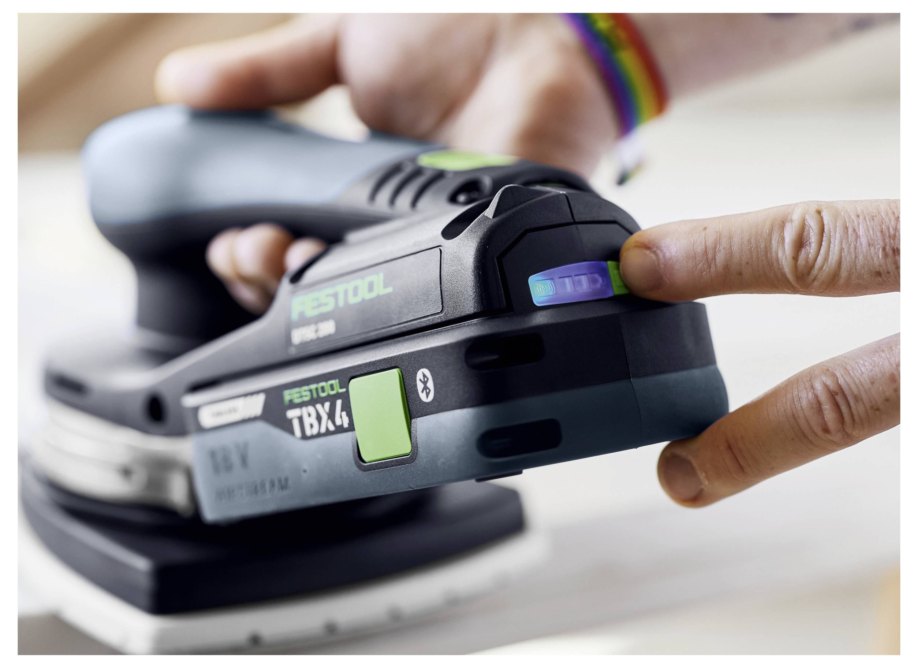 Eine Person, die eine Festool-Kreissäge auf einem Führungsschienensystem für präzise Schnitte verwendet, wobei ein Staubabsaugschlauch für einen sauberen Betrieb angebracht ist.