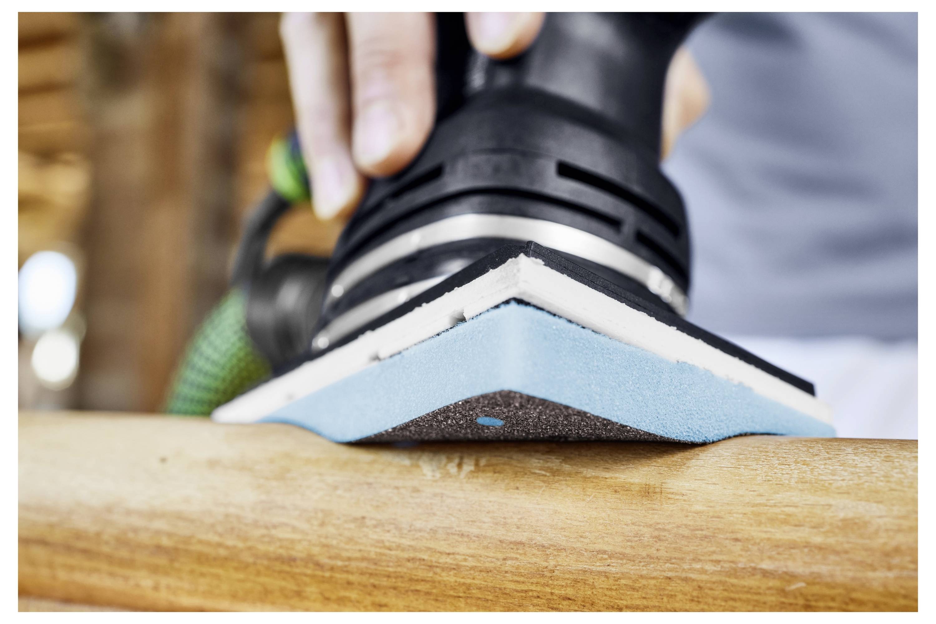 Eine Person in einem hellblauen Hemd hält ein kreisförmiges Objekt mit der Aufschrift „Medium