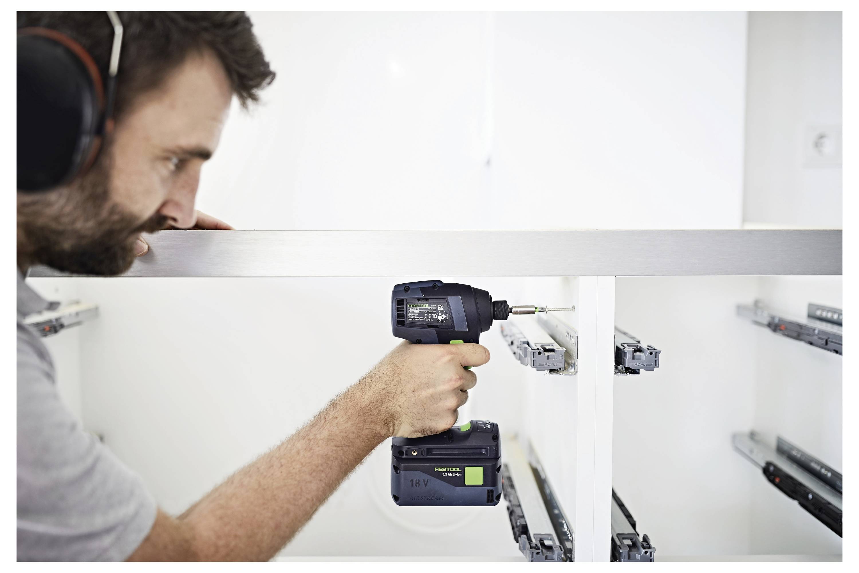 Zwei 18-V-Batterien mit grünen Anzeigen auf einem Doppelladegerät, einsatzbereit, zeigen die kabellose Kompatibilität für verschiedene Elektrowerkzeuge.