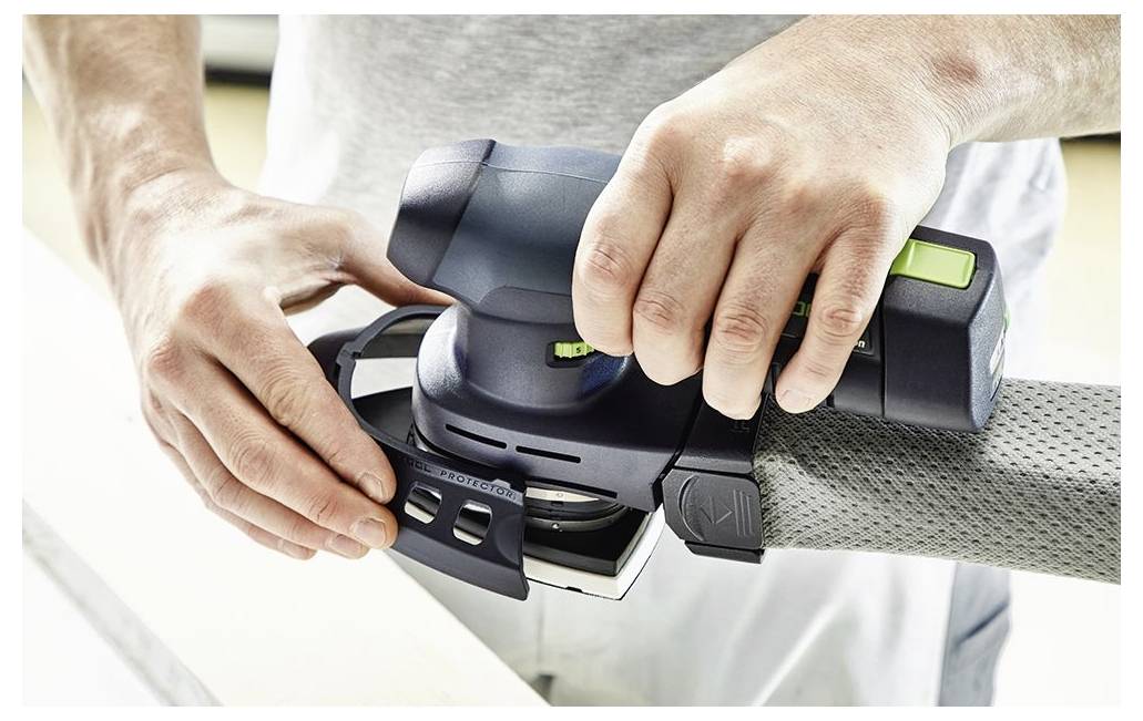 Person, die einen Elektroschleiffer auf einer Holzoberfläche verwendet und sich auf das Glätten von Kanten konzentriert.