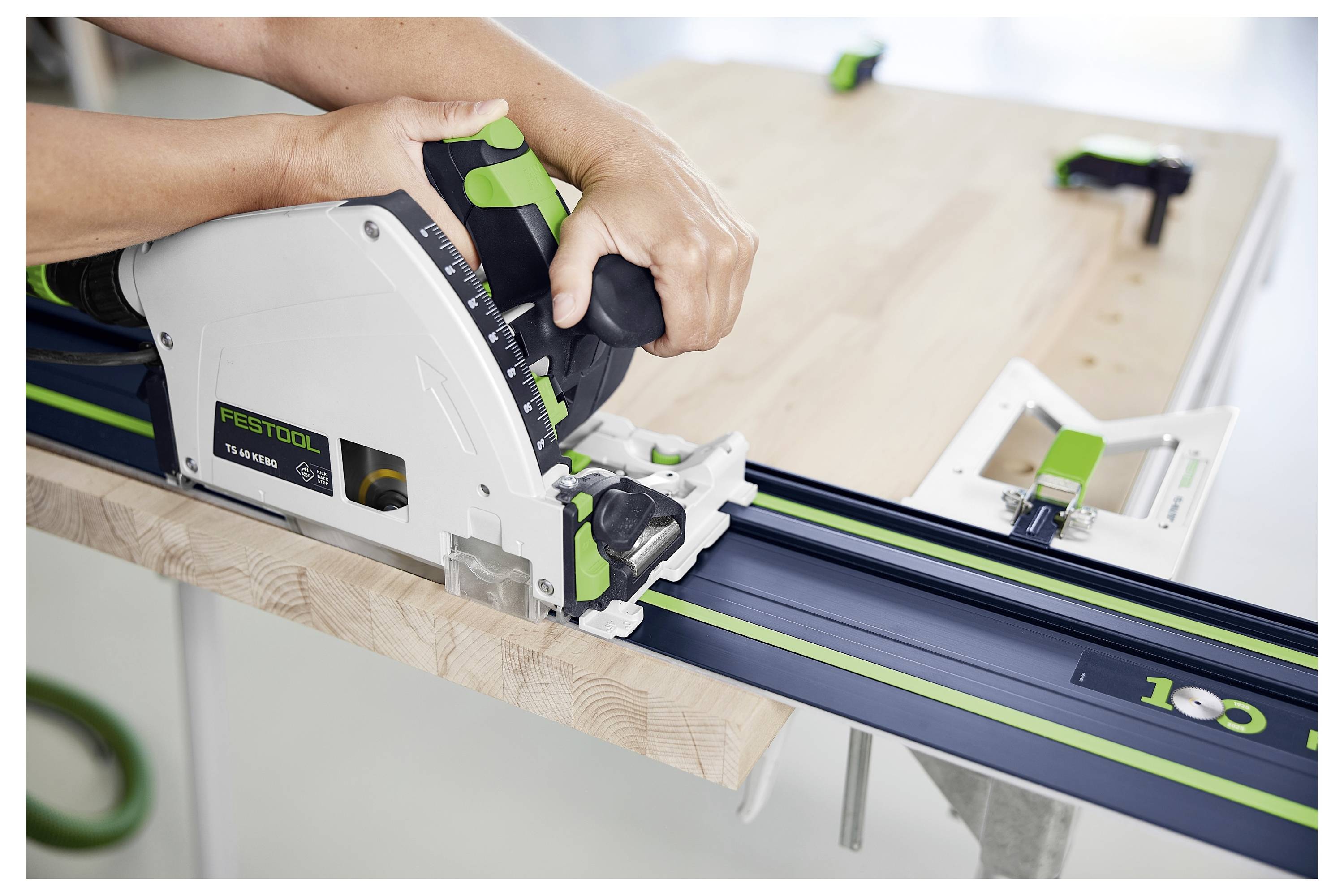 Eine Person benutzt ein tragbares Elektrowerkzeug, um durch einen Trockenbauabschnitt einer Decke zu schneiden und trägt dabei eine Schutzbrille zum Schutz.