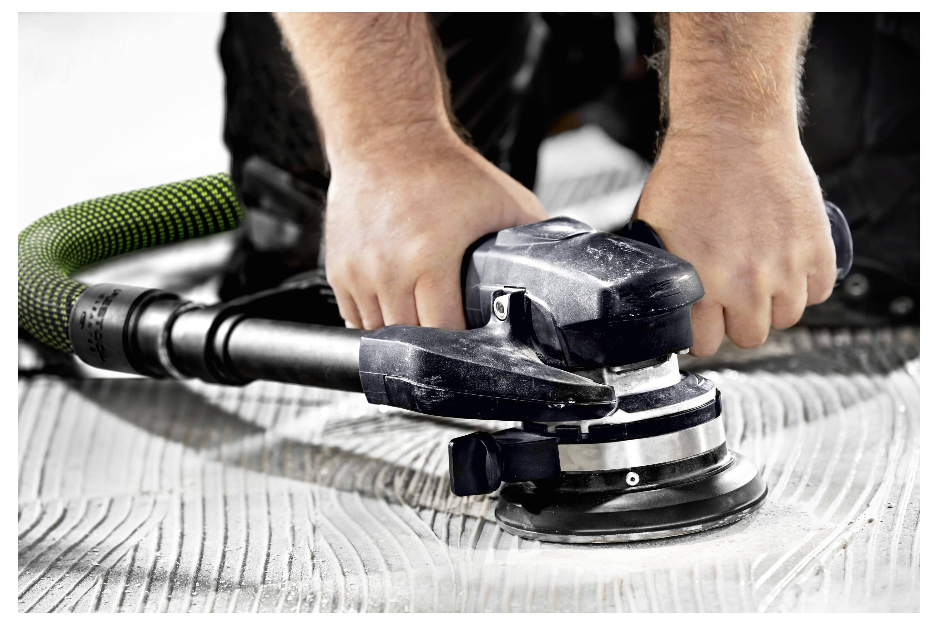 Eine Person verwendet ein Elektrowerkzeug, um Rost von einer blauen Metalloberfläche mit orangefarbenen Rostflecken zu entfernen.