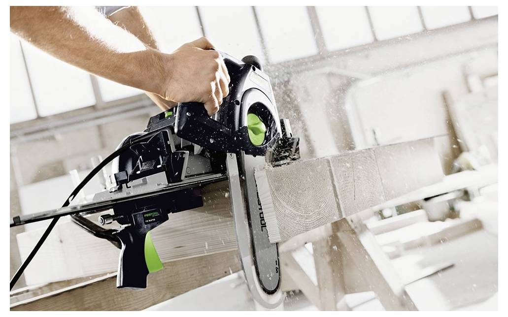 Ein tragbarer Elektromixer mit einer langen Metallanbringung ruht auf einem Betonboden in einem teilweise renovierten Raum mit Ziegel- und Gipswänden.