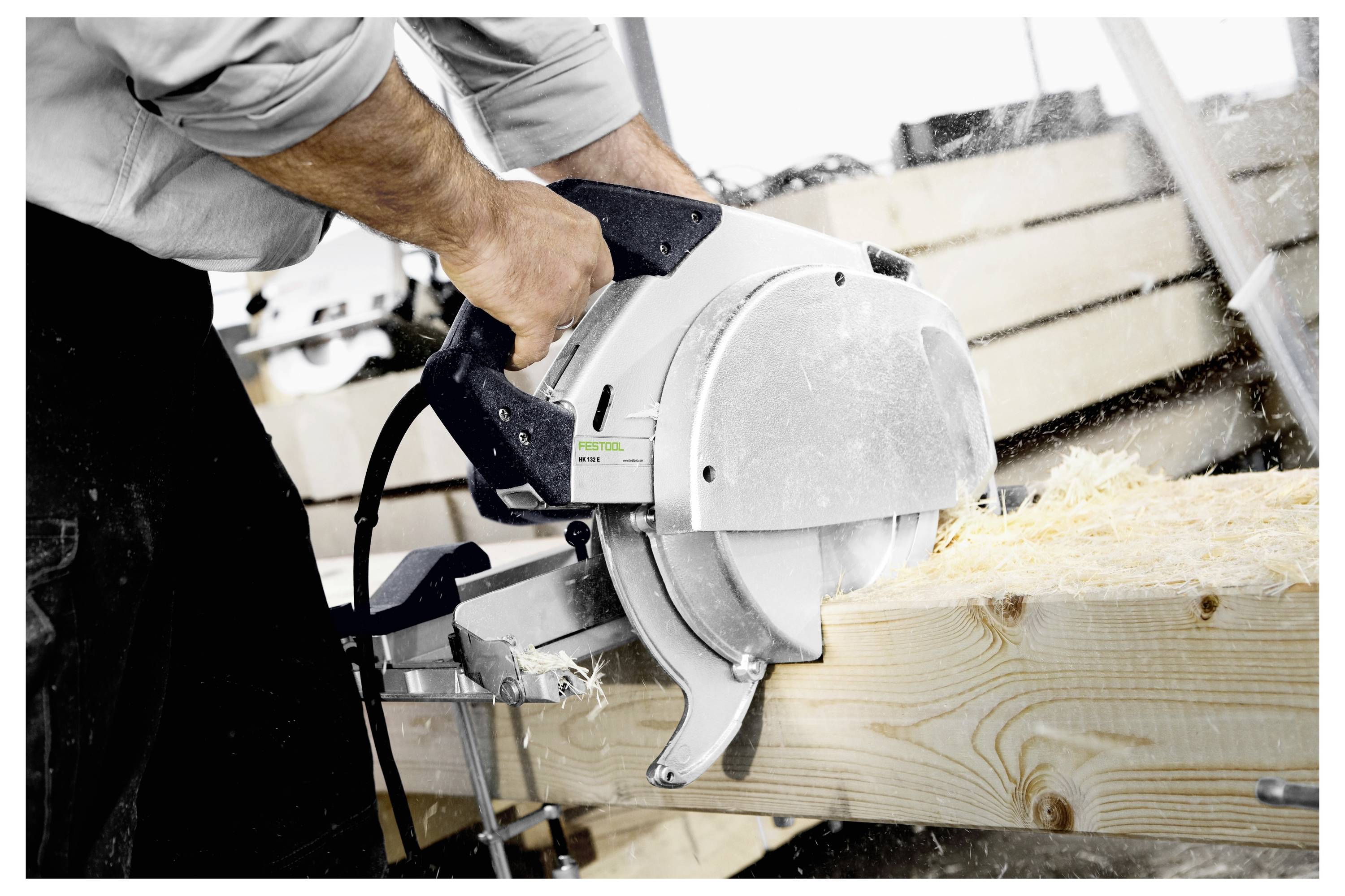 Eine Person nutzt ein Elektrowerkzeug, um eine Betonoberfläche zu durchschneiden, wobei der Fokus auf der Schneidklinge liegt, die mit dem Material in Kontakt kommt.