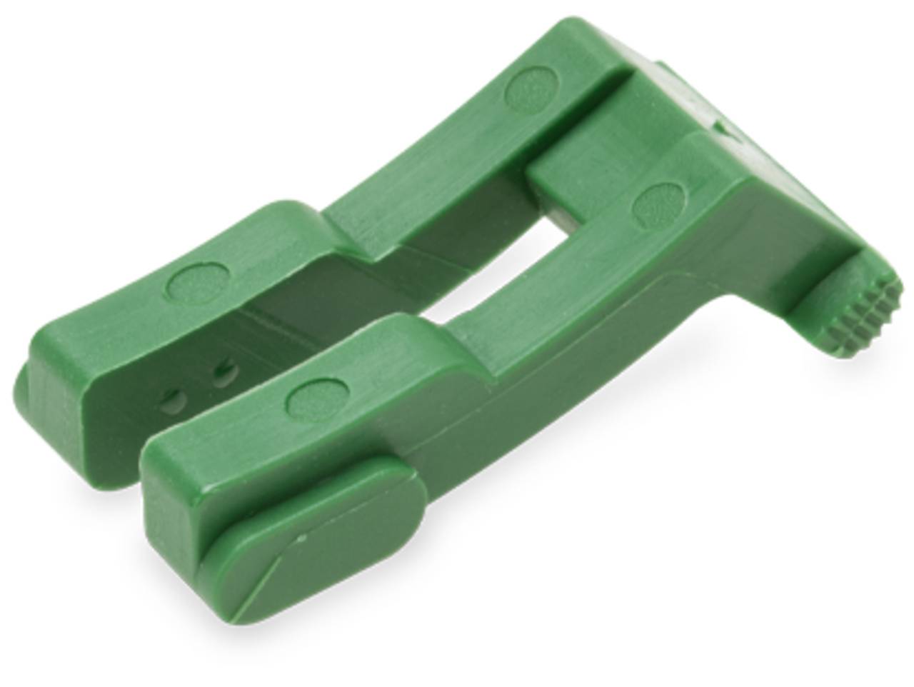 Eine grüne Kunststoffwäscheklammer mit abgerundeten Kanten, liegend auf einer weißen Oberfläche.