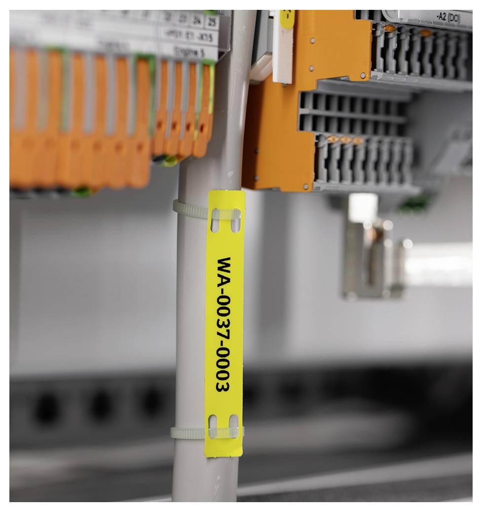 Ein beschriftetes Kabel ('WA-0037-0003') ist mit Kabelbindern vor organisierten Elektrosteckern in einer industriellen Umgebung gesichert.