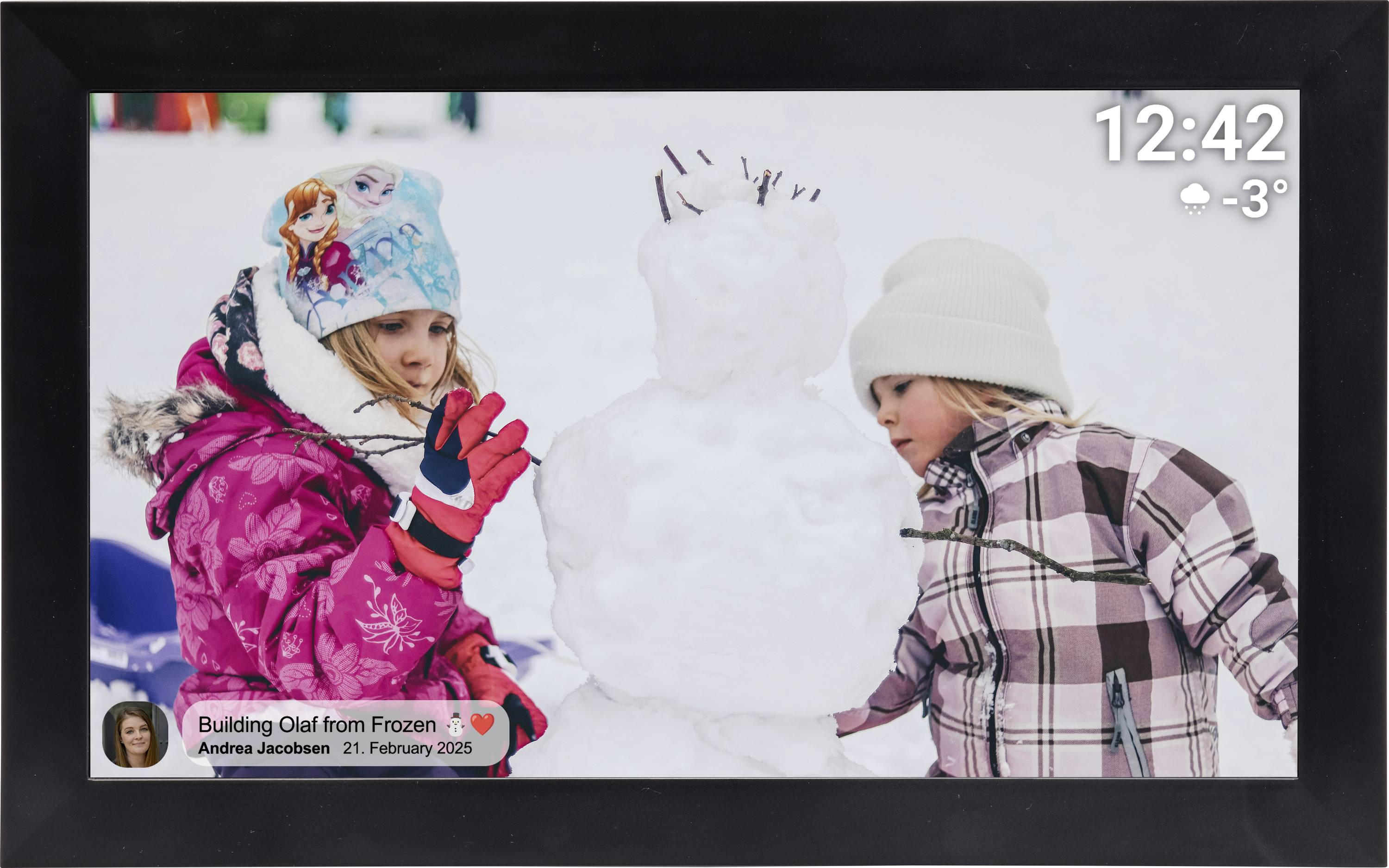 Zwei Kinder in Winterkleidung bauen draußen einen Schneemann, mit einer gerahmten Anzeige, die Zeit, Wetter und Fotobeschriftungsdetails zeigt.