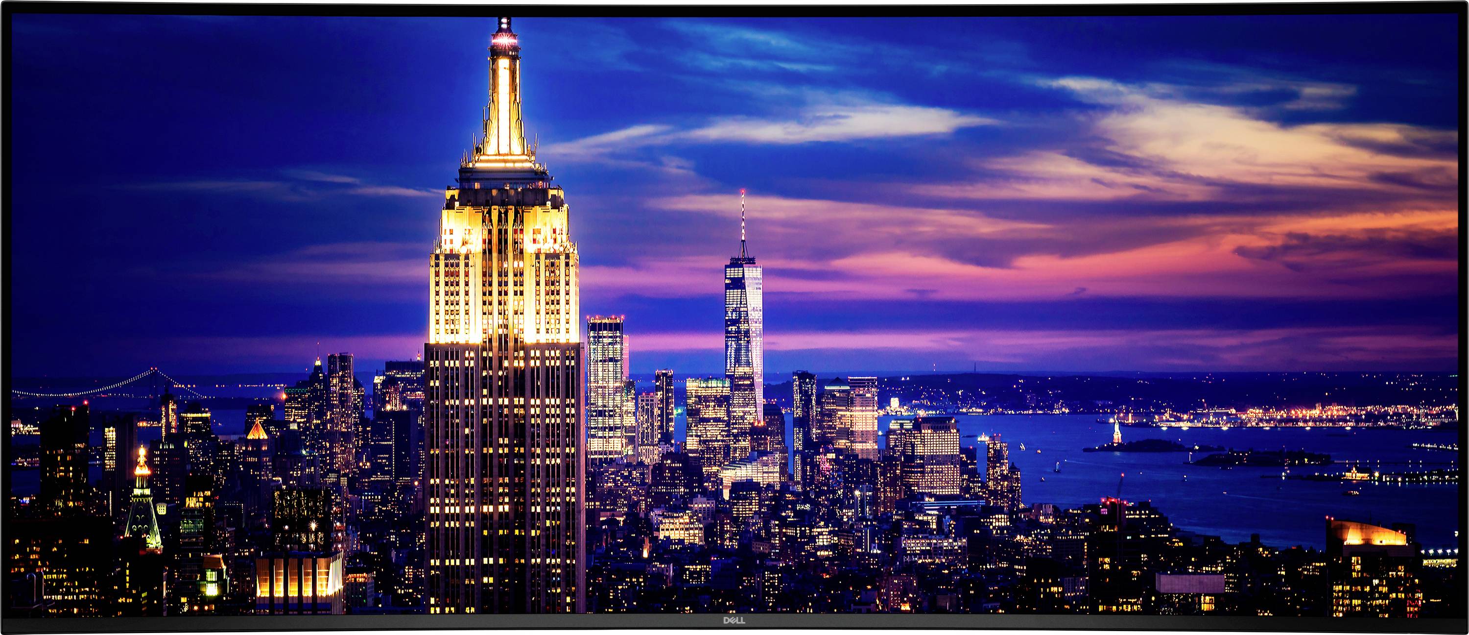 Das Bild zeigt eine nächtliche Stadtlandschaft von New York City mit dem leuchtenden Empire State Building im Vordergrund und der Skyline im Hintergrund.