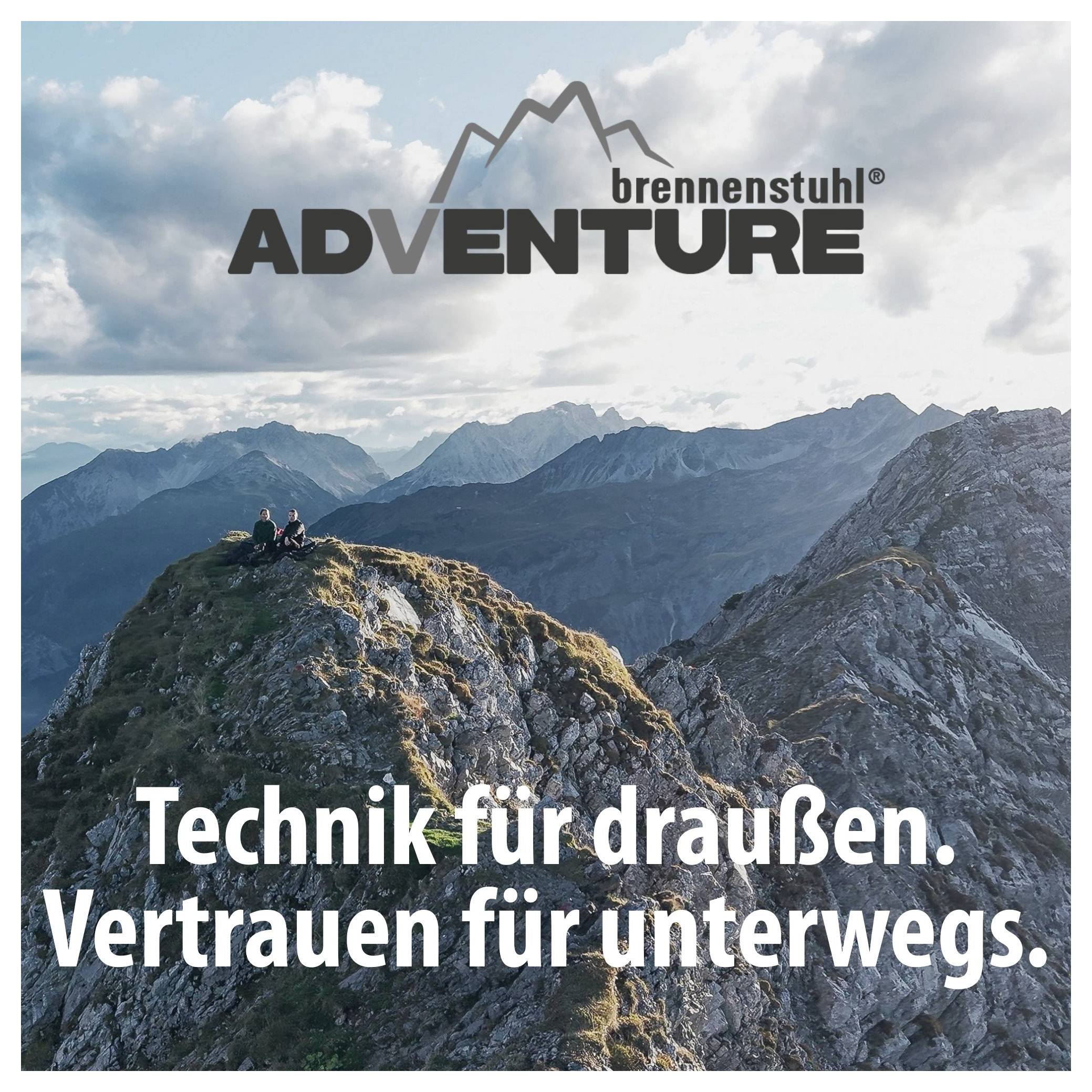 Werbeplakat von 'brennenstuhl ADVENTURE' mit Berglandschaft und Wanderern auf einem Gipfel; Slogan: 'Technik für draußen. Vertrauen für unterwegs.'