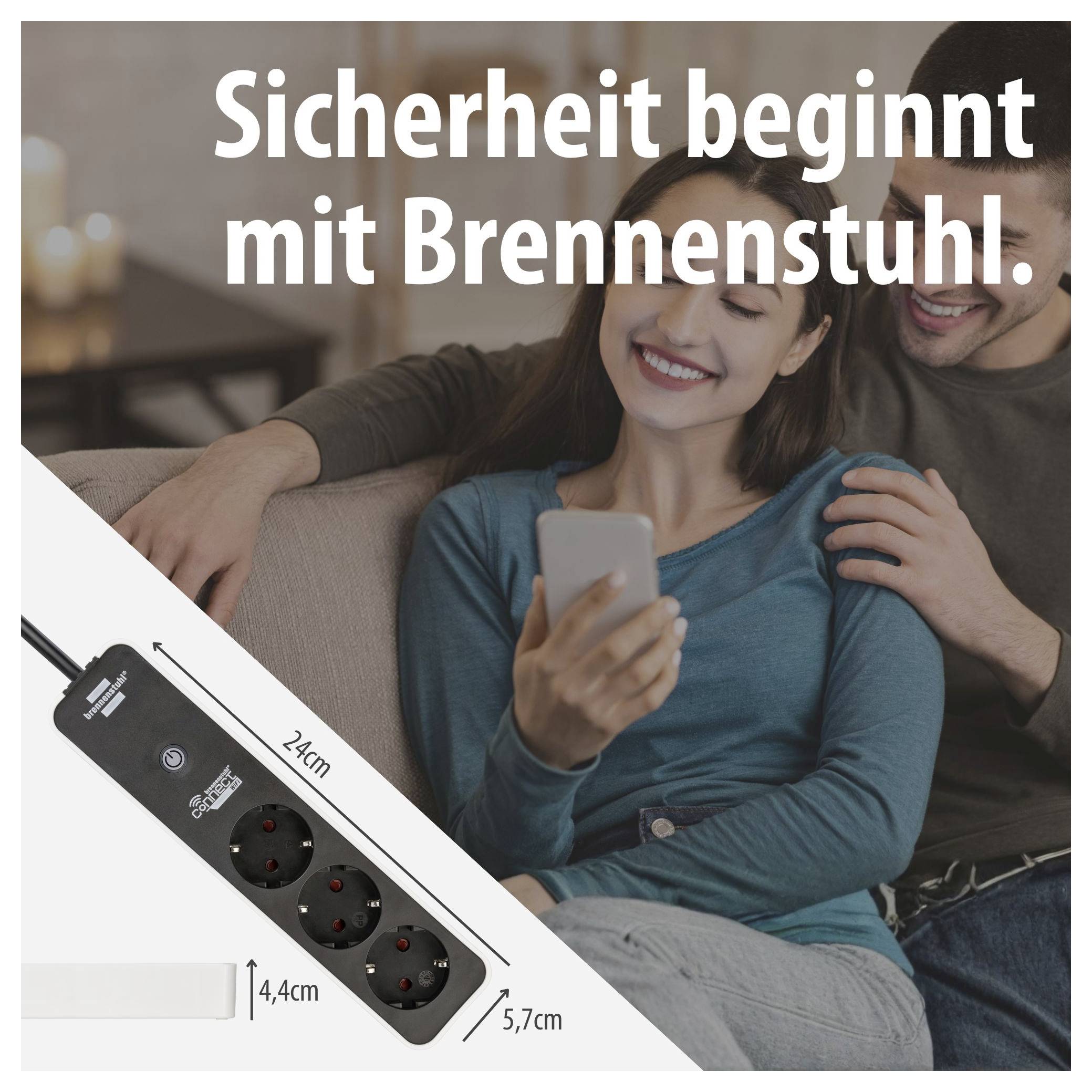 Werbegrafik mit Paar auf dem Sofa und Steckdosenleiste; Text: 'Sicherheit beginnt mit Brennenstuhl.'; zeigt eine schwarze Mehrfachsteckdose mit 24 cm Länge, 4,4 cm Höhe und 5,7 cm Breite.