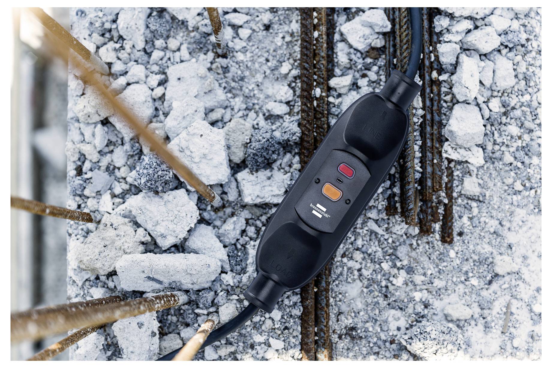 Ein Leistungsschutzschalter auf einer Baustelle liegt auf Schutt mit rostigem Bewehrungsstahl und zeigt Sicherheitsmechanismen in Arbeit während des Baus.