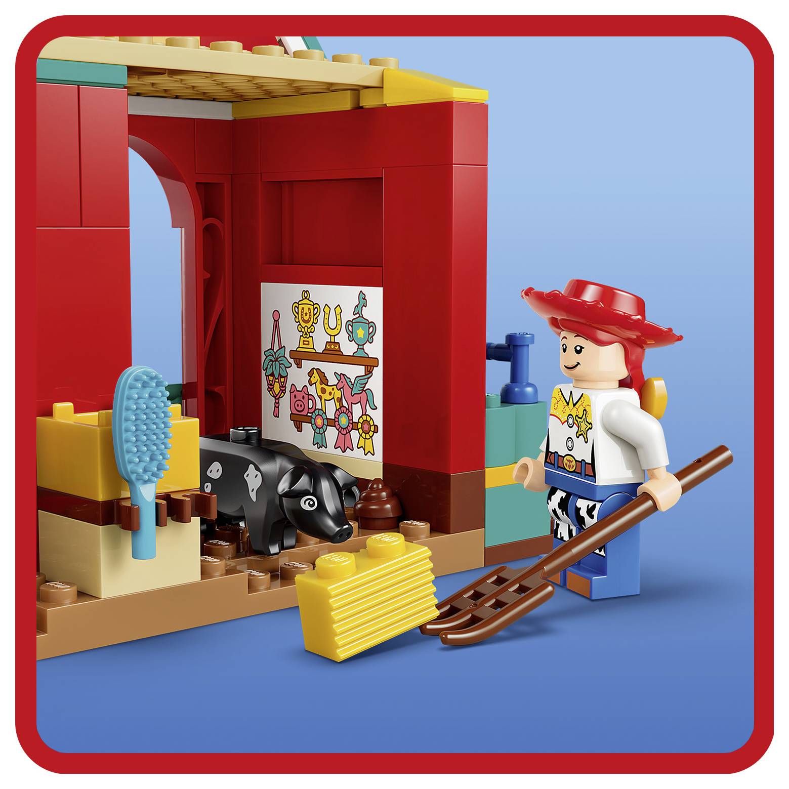 LEGO-Spielszene mit Jessie aus Toy Story, einer schwarzweißen Kuh, einem Besen, einer Bürste und einem roten Stall-Hintergrund.