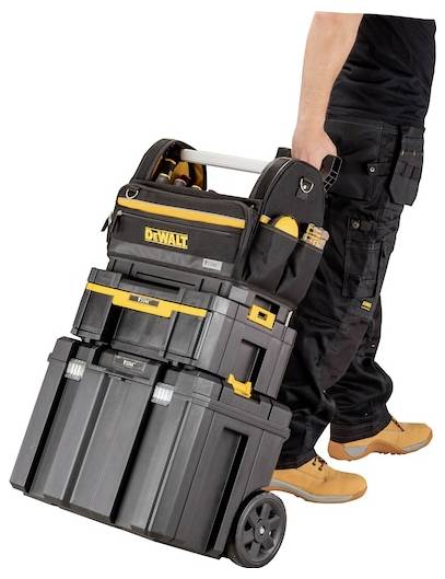 Eine Person in Arbeitsstiefeln und schwarzer Hose zieht eine gestapelte DeWalt-Werkzeugkiste auf Rädern, die zum Transport von Werkzeugen und Ausrüstung geeignet ist.