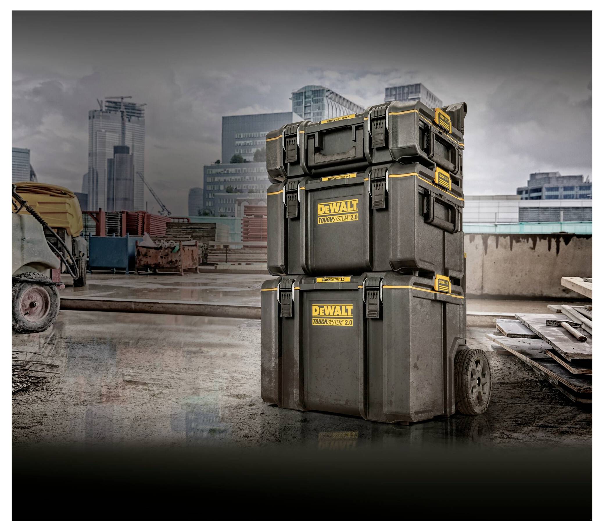 Gestapelte DEWALT-Werkzeugkästen auf einer Baustelle mit einer Stadtsilhouette im Hintergrund, wobei Speicherung und Mobilität hervorgehoben werden.