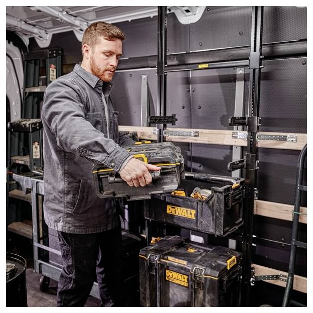 Eine Person in einem Arbeitsvan organisiert Werkzeugkästen mit der Aufschrift 