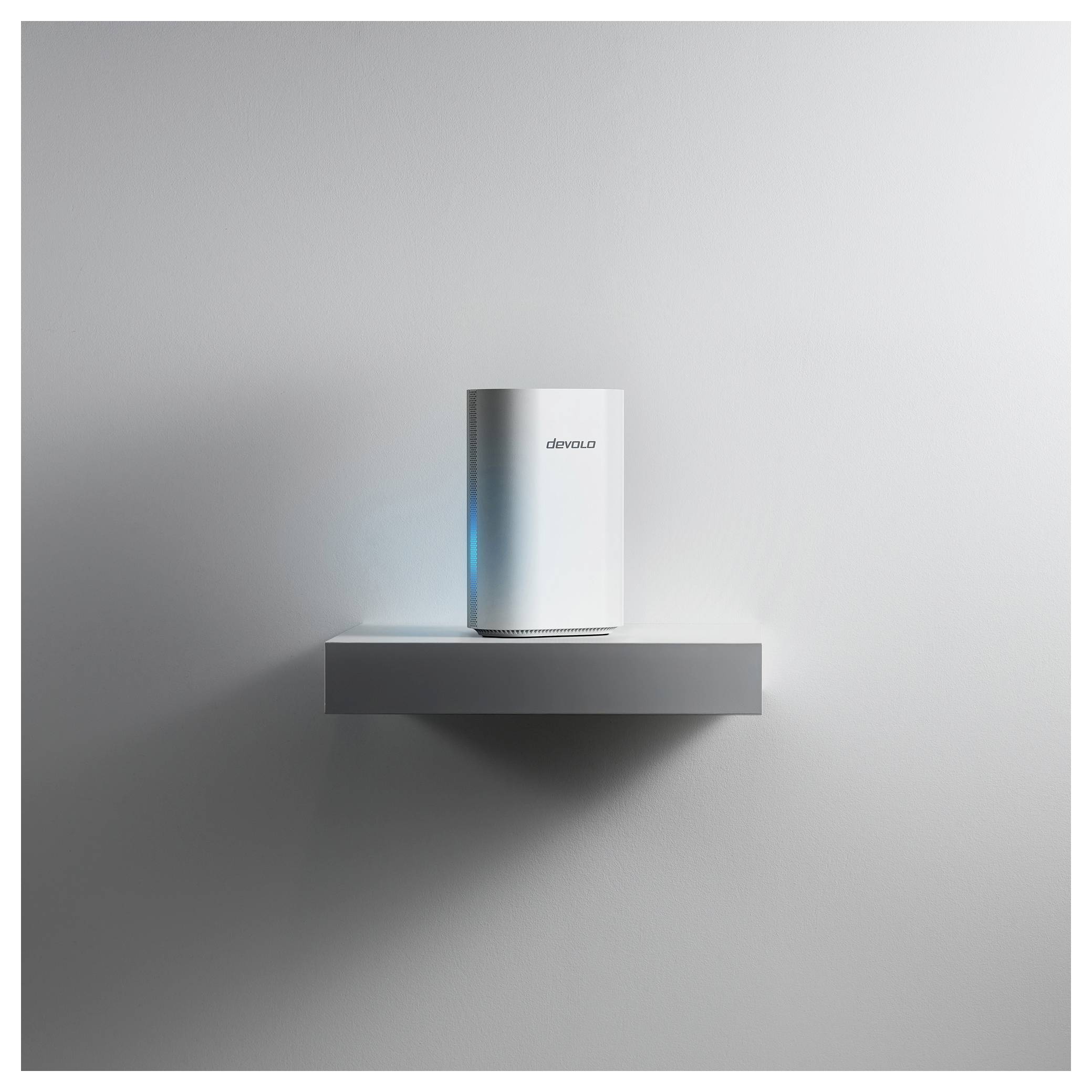 Ein weißer, zylindrischer Wi-Fi-Router mit leuchtend blauem Licht steht auf einem minimalistischen grauen Wandregal vor einem schlichten Hintergrund.