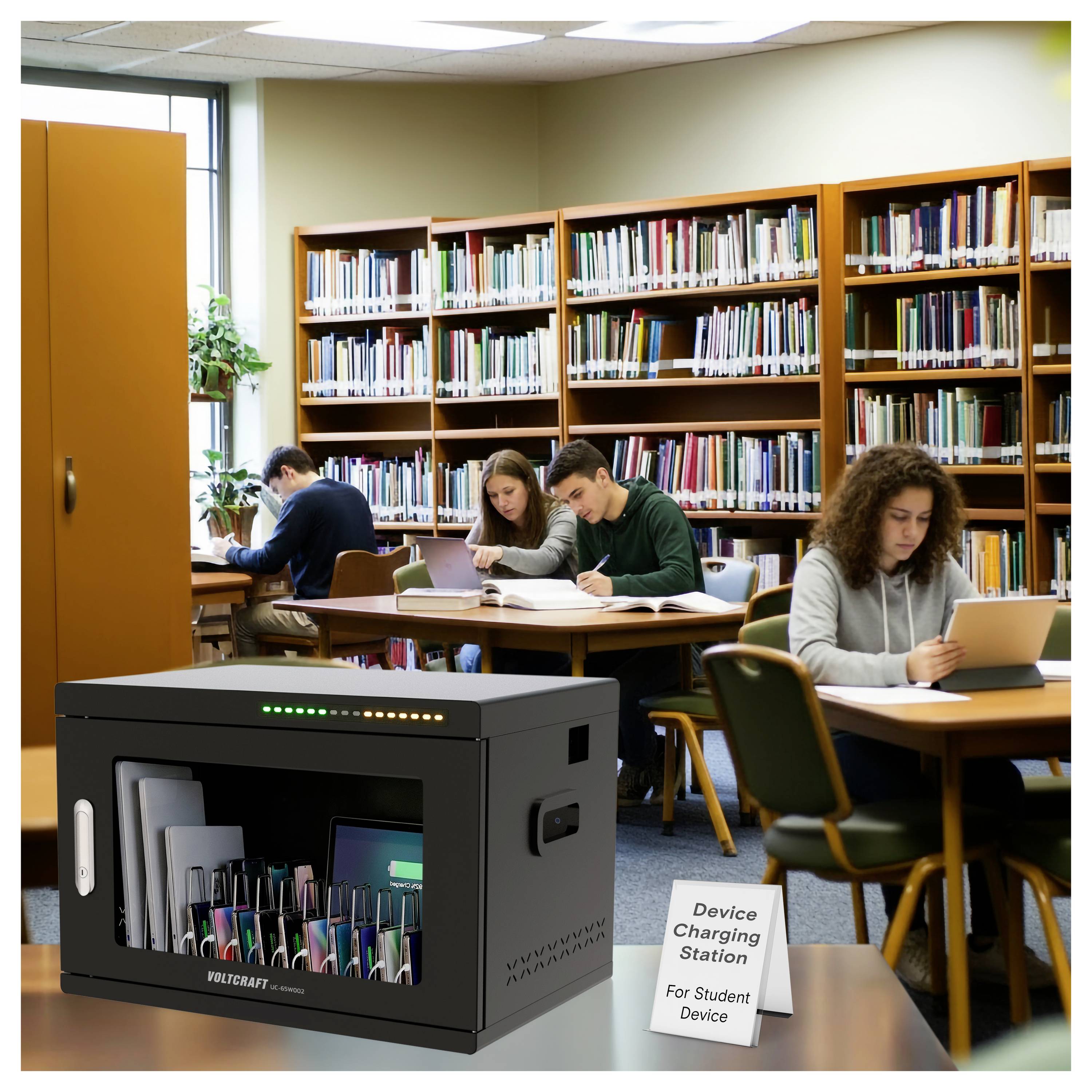Bibliotheksstudienraum mit Studierenden, die an Tischen lesen, und eine Ladestation für Studentengeräte im Vordergrund.