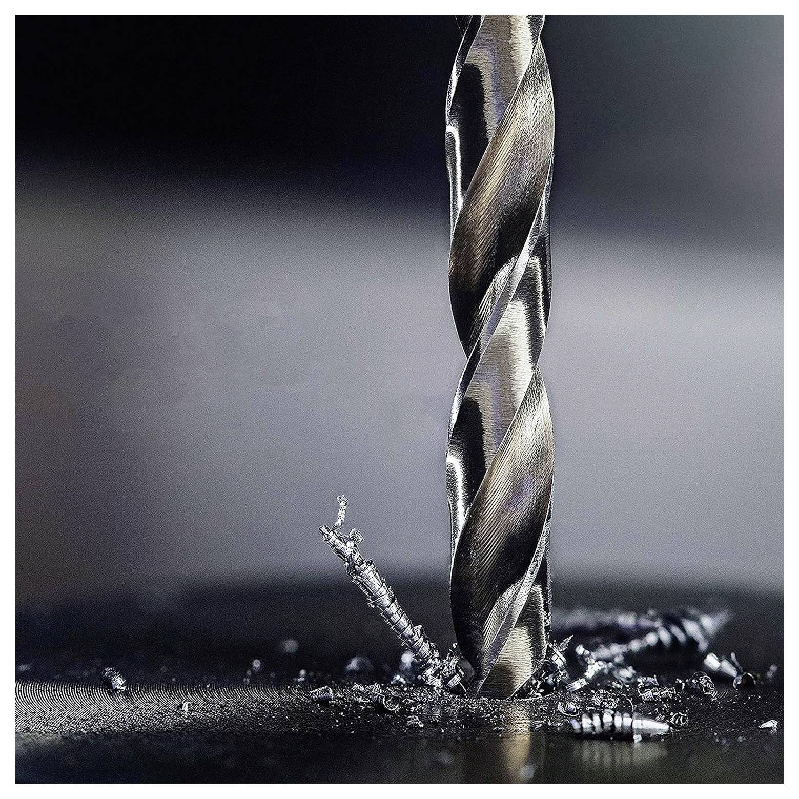 Ein Bohrmeißel, der in eine Metalloberfläche eindringt, umgeben von Metallspänen, was Bearbeitungs- oder Bauarbeiten veranschaulicht.