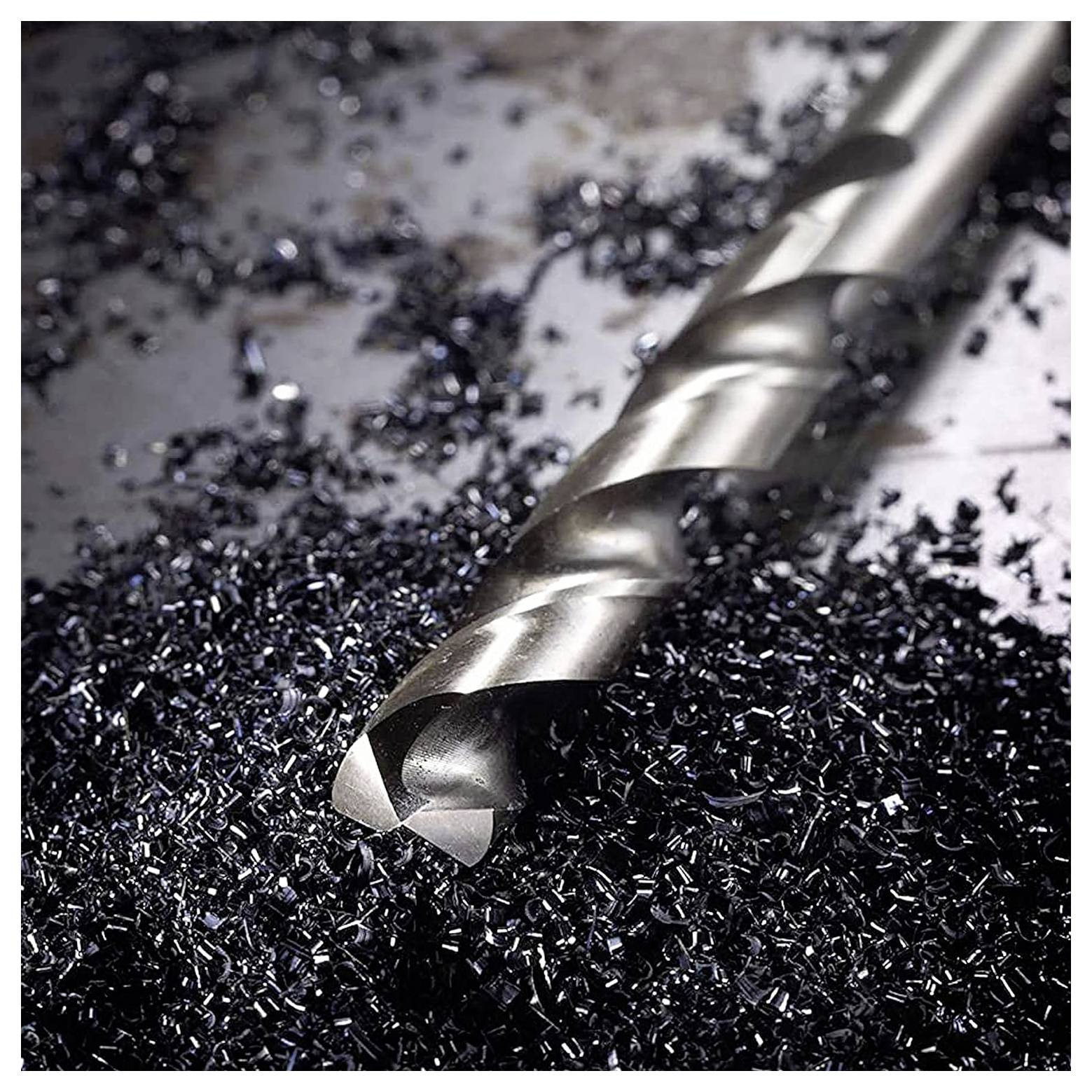 Nahaufnahme eines Metallbohrers, umgeben von verstreuten Metallspänen auf einer Oberfläche, die handwerkliche Arbeit oder Bearbeitung betont.
