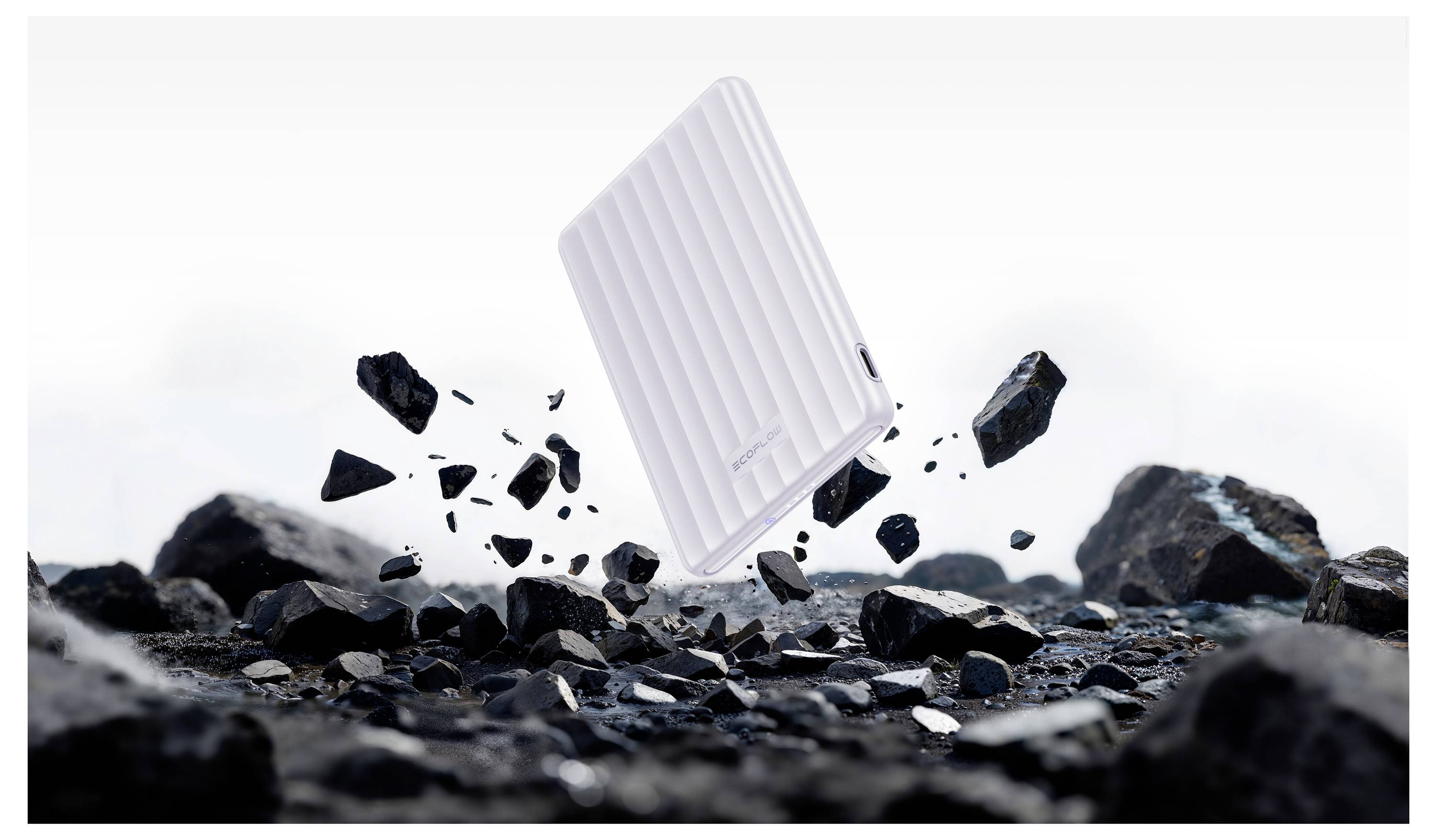 Eine weiße tragbare Festplatte umgeben von schwebenden schwarzen Steinen, die Haltbarkeit und Widerstandsfähigkeit in rauen Umgebungen suggerieren.
