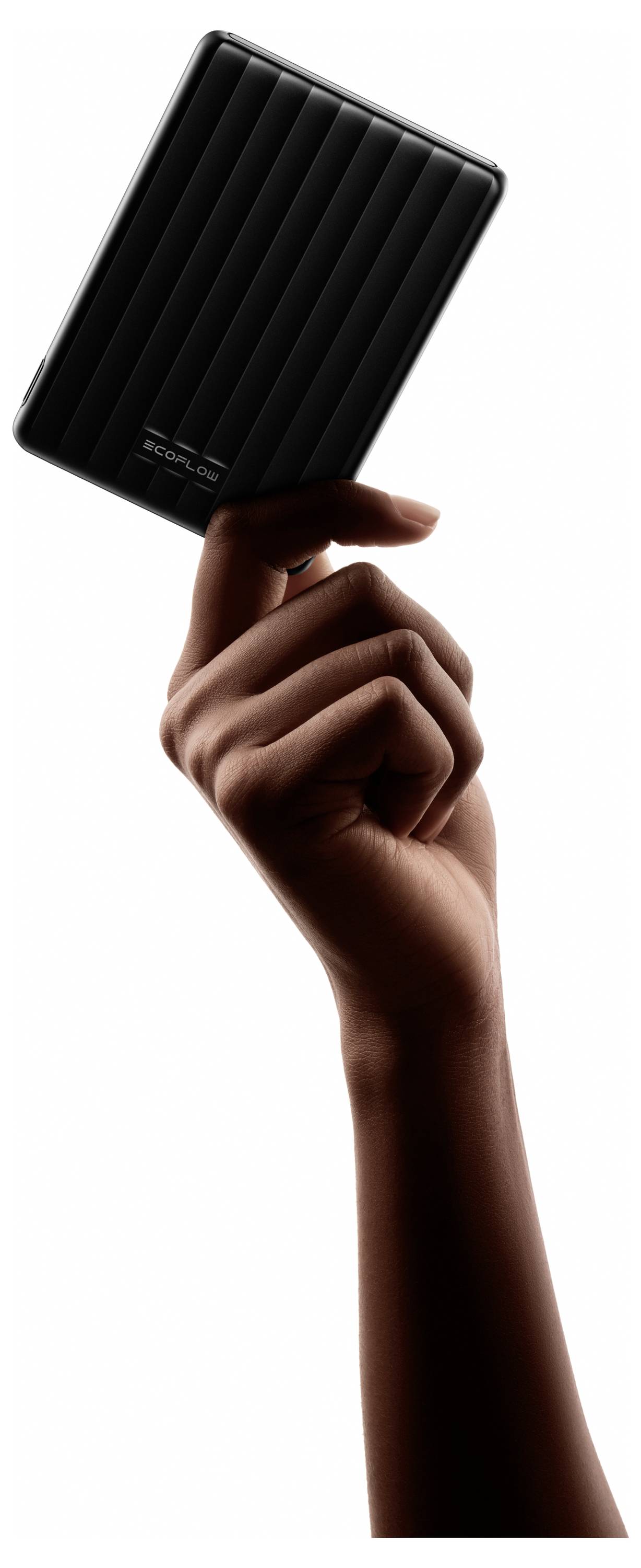 Eine Hand, die ein schlankes, rechteckiges, schwarzes externes Festplattenlaufwerk vertikal vor einem weißen Hintergrund hält.