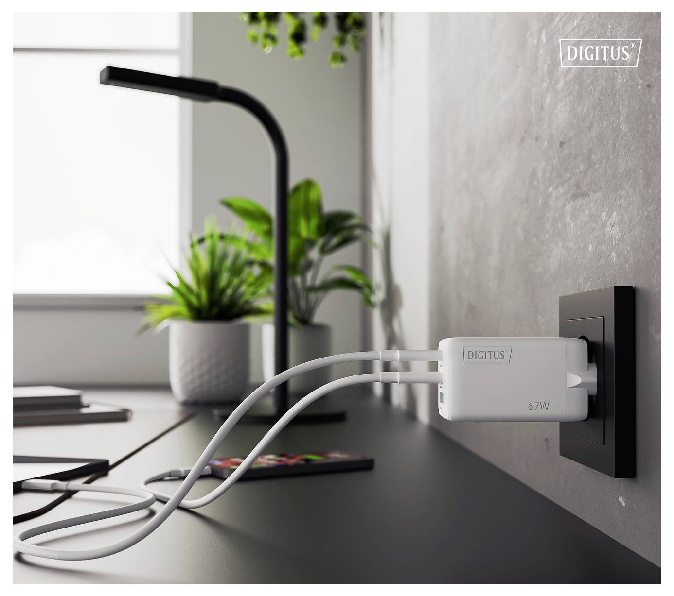 Ein minimalistischer Schreibtisch mit Topfpflanzen und einer Lampe. Ein Multi-Port-Ladegerät mit der Bezeichnung „67W