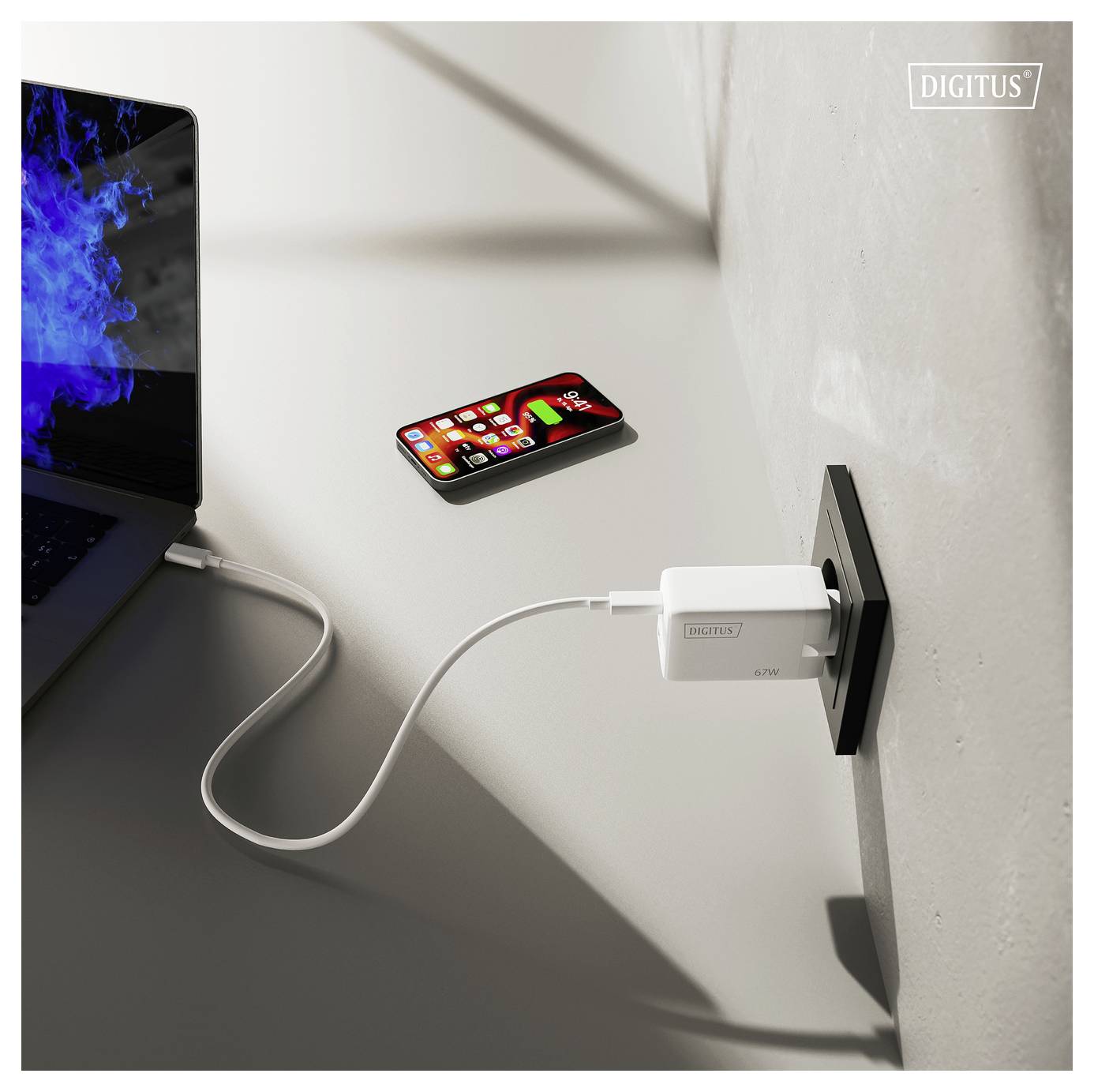 Ein Smartphone und ein Laptop, die über USB-Kabel an ein Wandladegerät angeschlossen sind, in einer modernen Umgebung, die effizientes Multitasking hervorhebt.