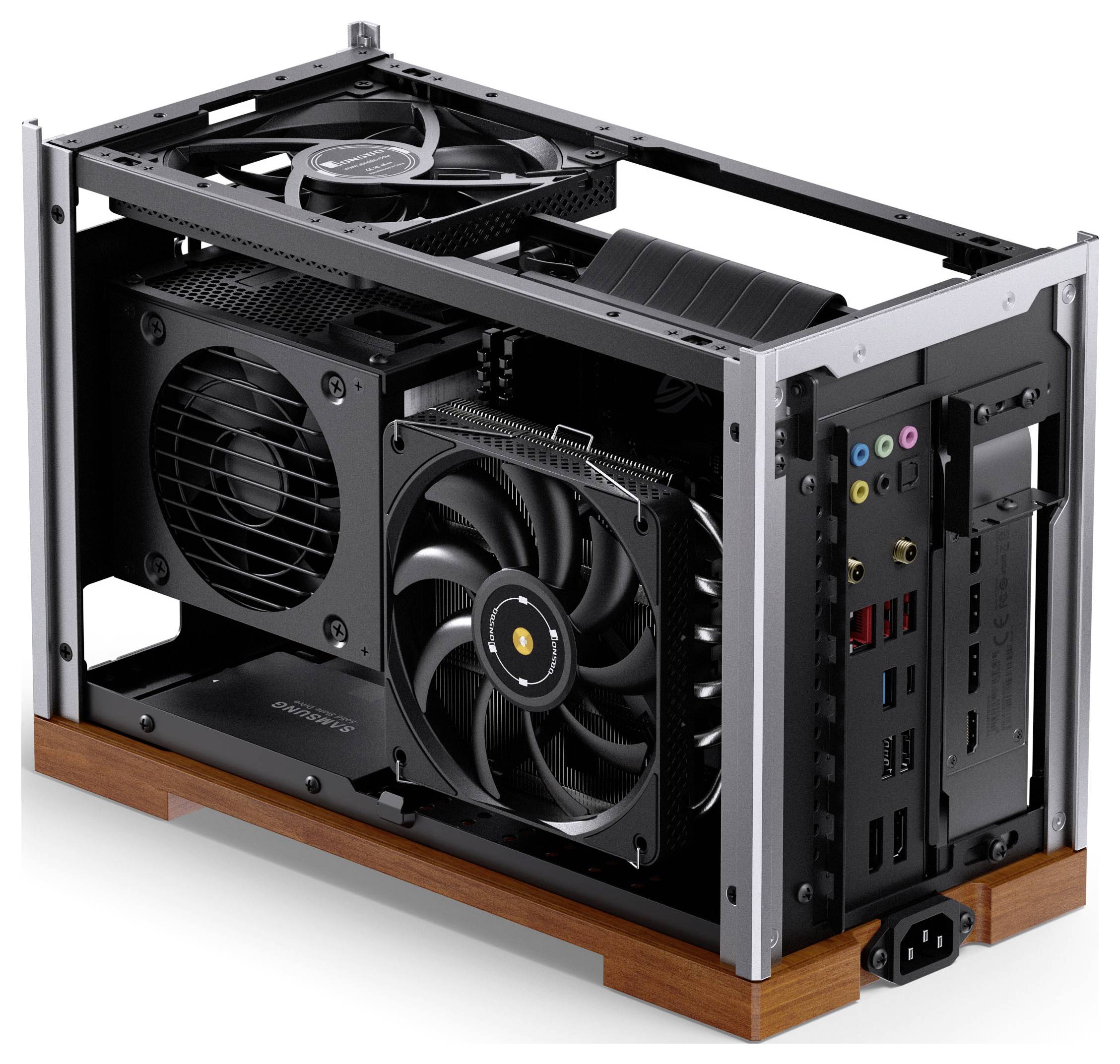 Ein kompaktes offenes Computergehäuse mit verschiedenen Kühlventilatoren, Anschlüssen und einem Netzteil im Inneren, präsentiert auf einer Holzplattform.