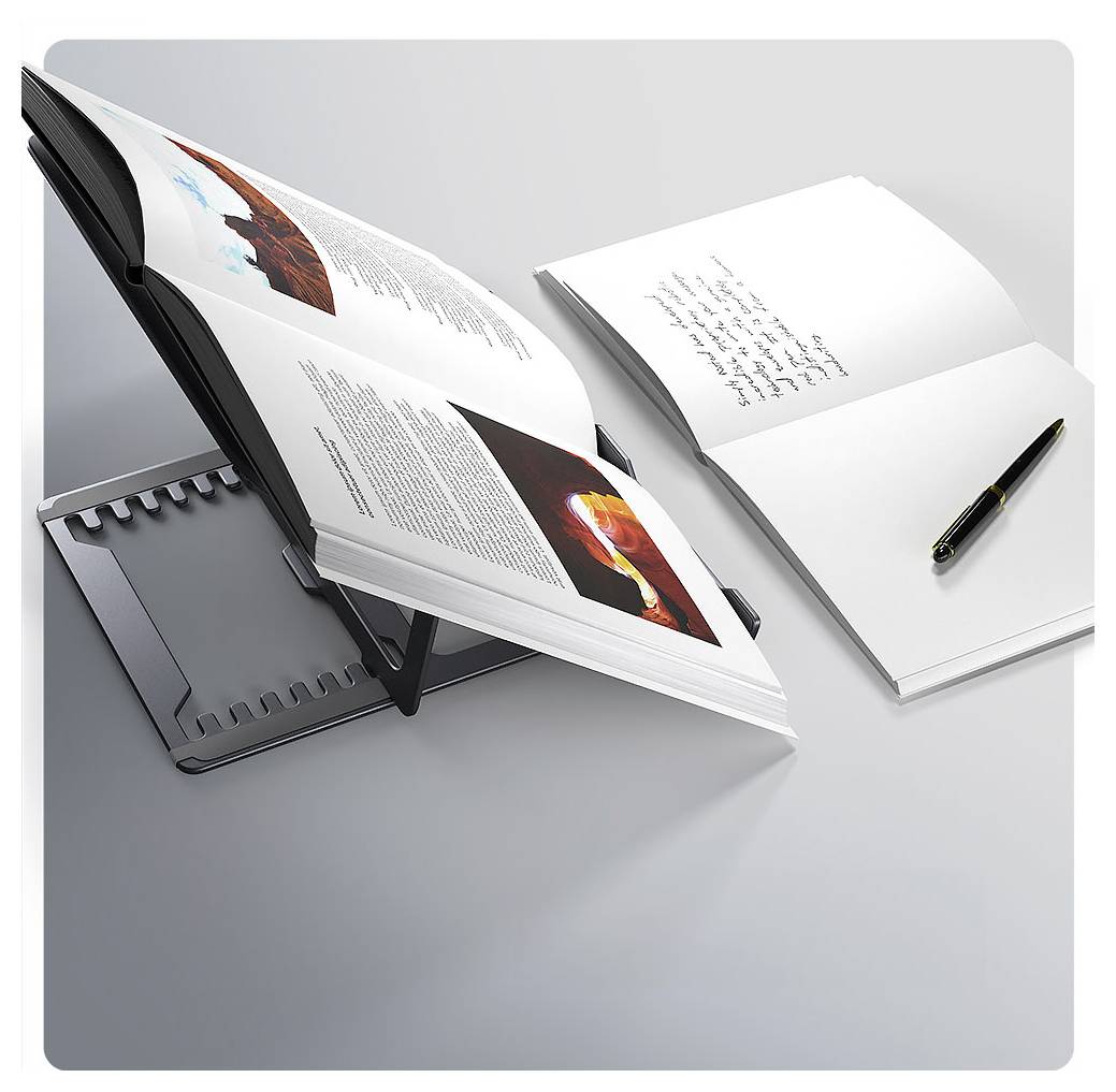 Ein aufgeschlagenes Buch steht auf einem Buchständer neben einem offenen Notizbuch mit handschriftlichem Text und einem schwarzen Stift auf einer hellhellen Oberfläche.