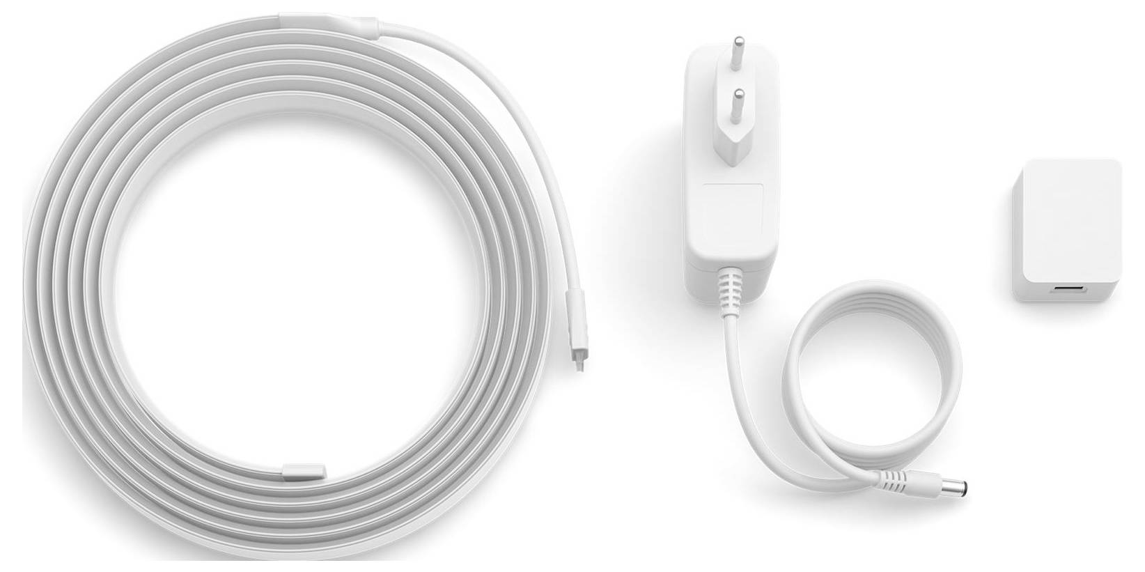 Ein langes aufgerolltes Kabel, ein Stecker mit kurzem Kabel und ein kleiner Adapter sind nebeneinander vor einem einfachen Hintergrund angeordnet.