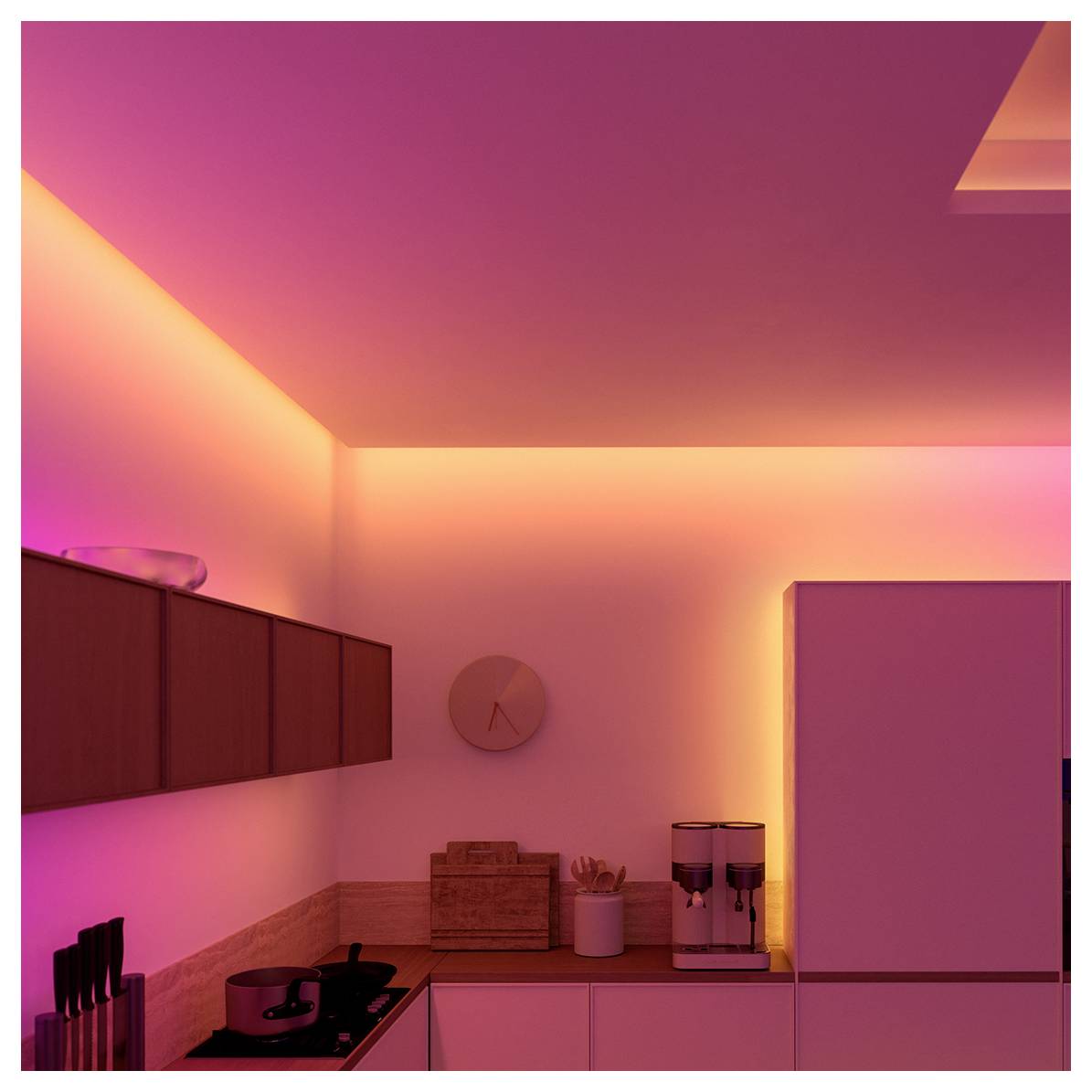 Eine moderne Küche mit atmosphärischer rosa Beleuchtung, ausgestattet mit Schränken, einem Herd und einem Kühlschrank, die eine warme und einladende Atmosphäre schaffen.