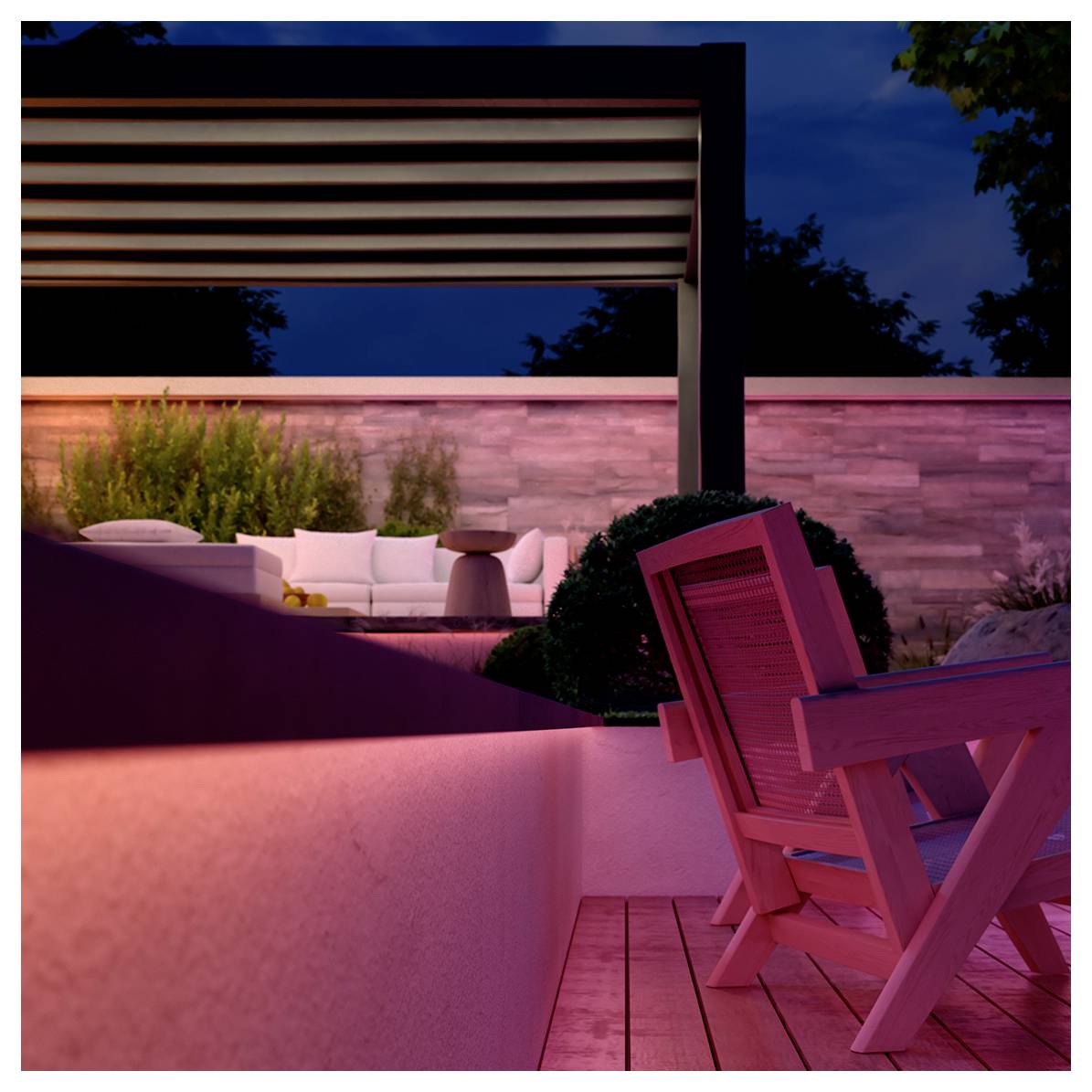 Modernes Außenambiente in der Abenddämmerung mit Holzstühlen, Umgebungsbeleuchtung und einer Pergola. Eine Steinmauer und üppiges Grün im Hintergrund.