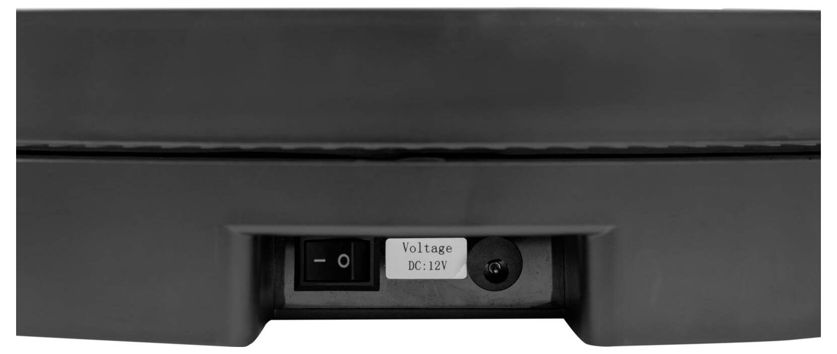 Das Bild zeigt eine Nahaufnahme eines Stromschalters und ein Etikett mit der Aufschrift „Spannung DC: 12V