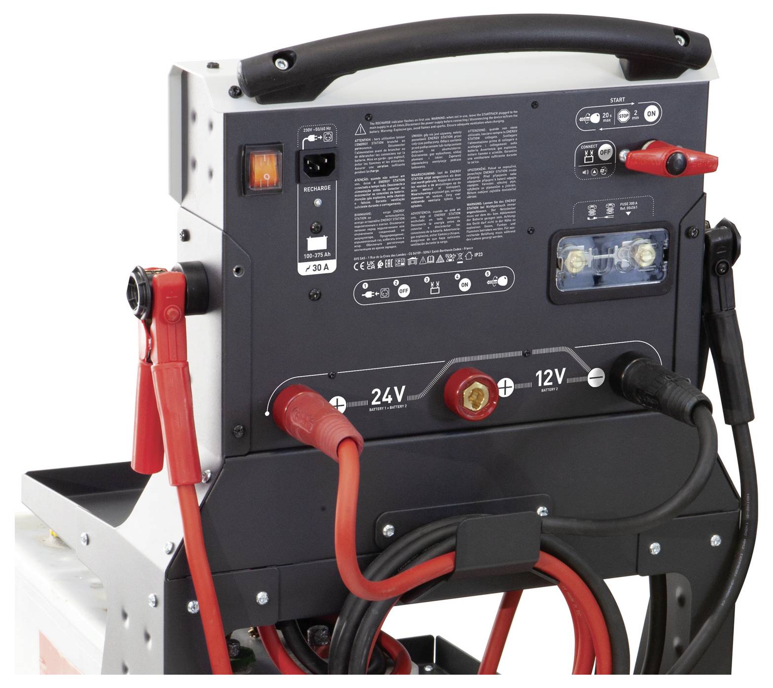Ein Nahaufnahmebild mit schwarzen und roten Automobilbatterieklammern mit angeschlossenen Kabeln, neben einem Stromstecker und Adapter.
