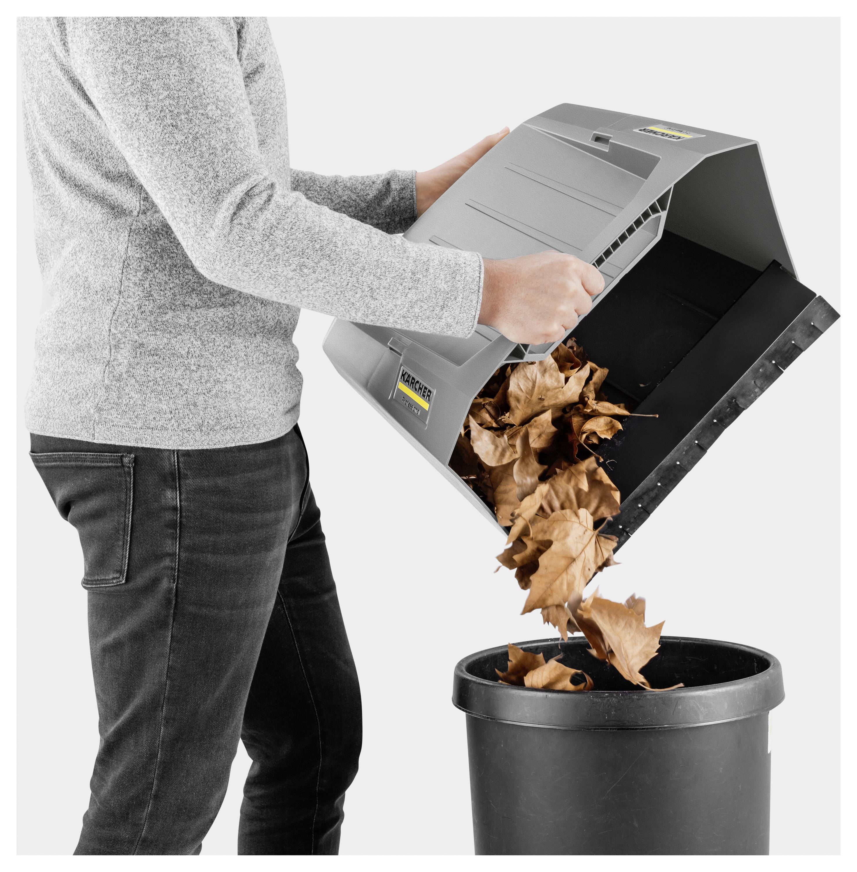 Eine Person leert getrocknete Blätter aus einer Maschine in einen schwarzen Behälter und demonstriert dabei den Prozess der Blattsammlung und Entsorgung.