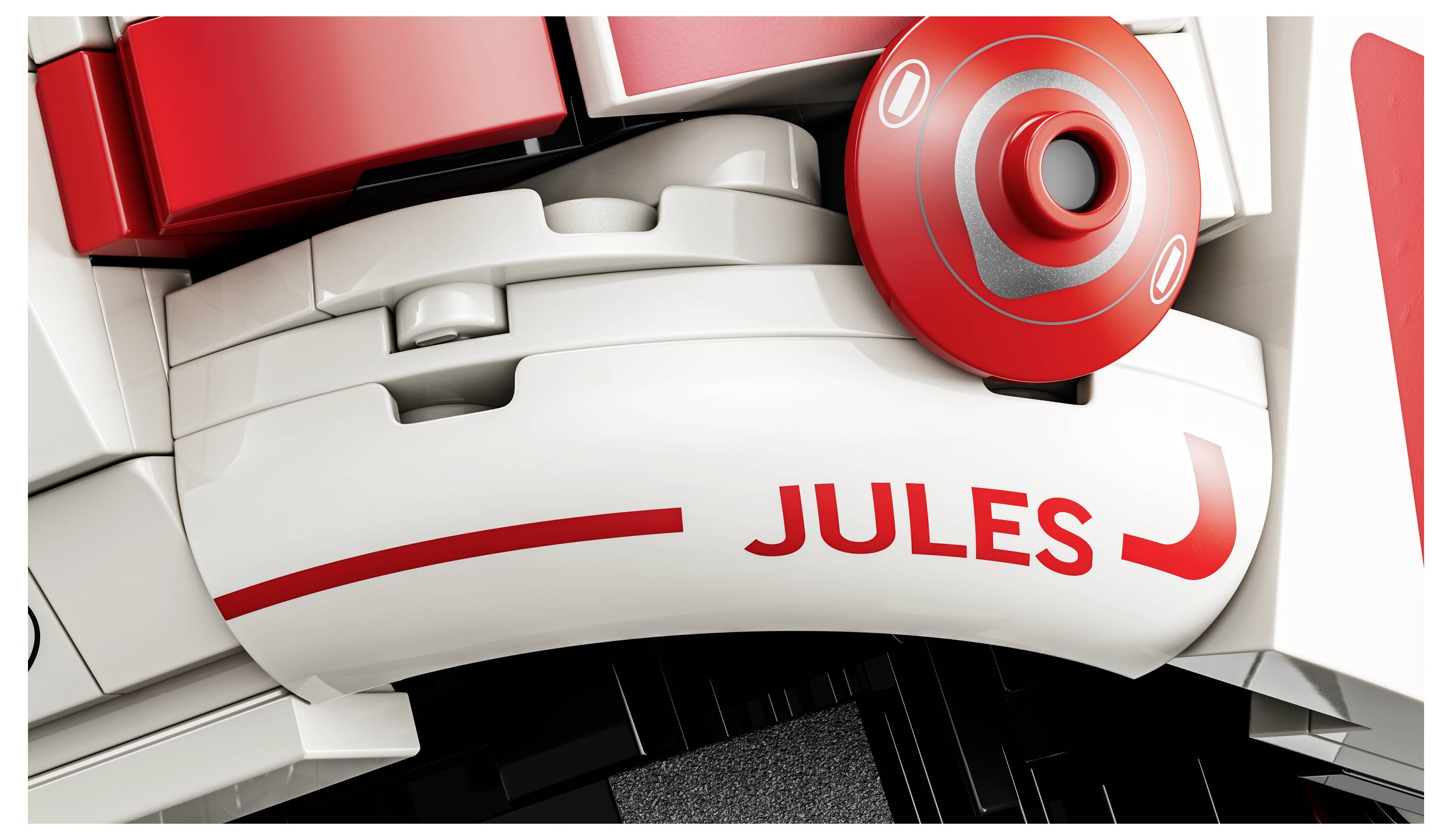 Nahaufnahme eines LEGO-Steins mit rot-weißem Design, auf dem der Name 'Jules' in Rot gedruckt ist.
