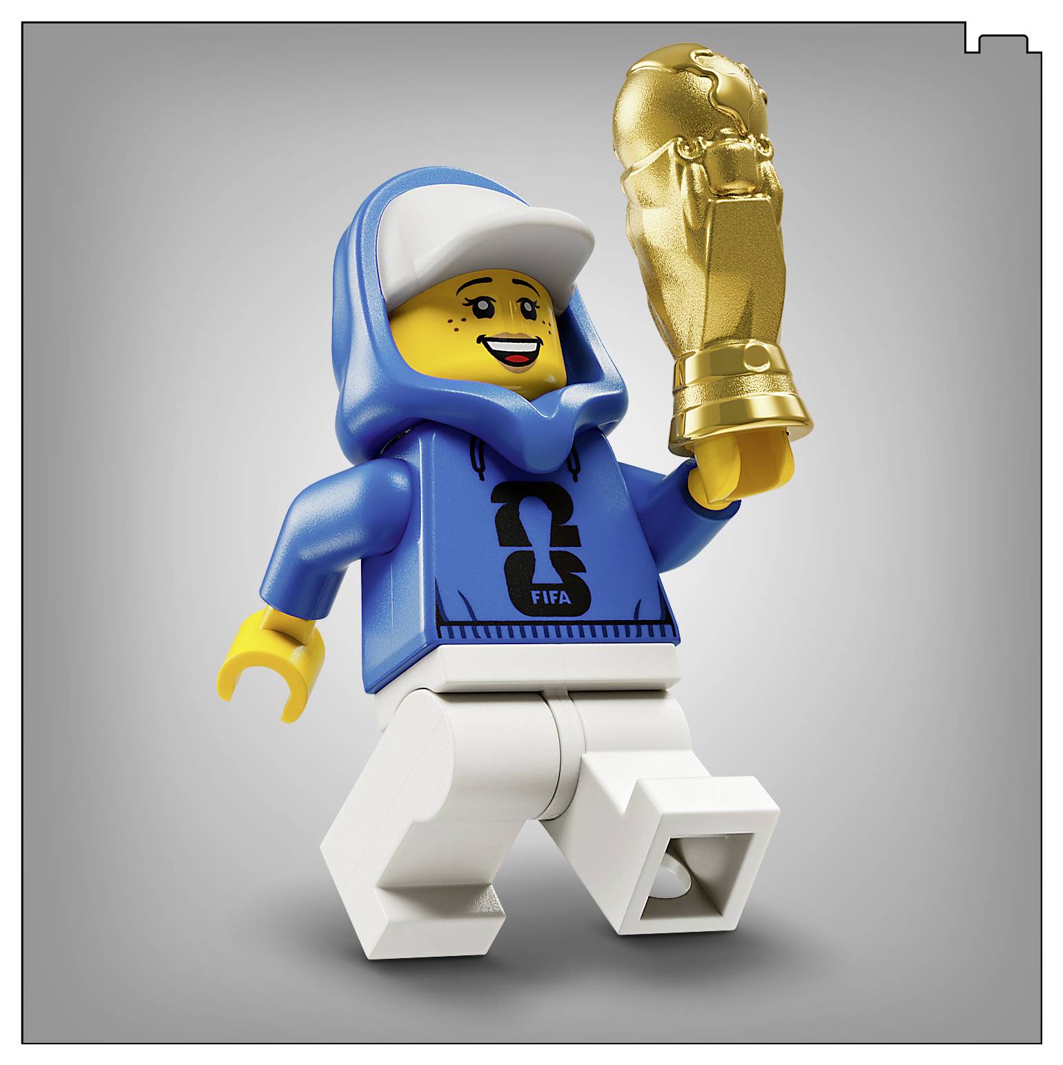 Eine LEGO-Figur, die einen blauen Hoodie und weiße Hosen trägt, hält eine goldene Trophäe und lächelt strahlend vor einem neutralen Hintergrund.