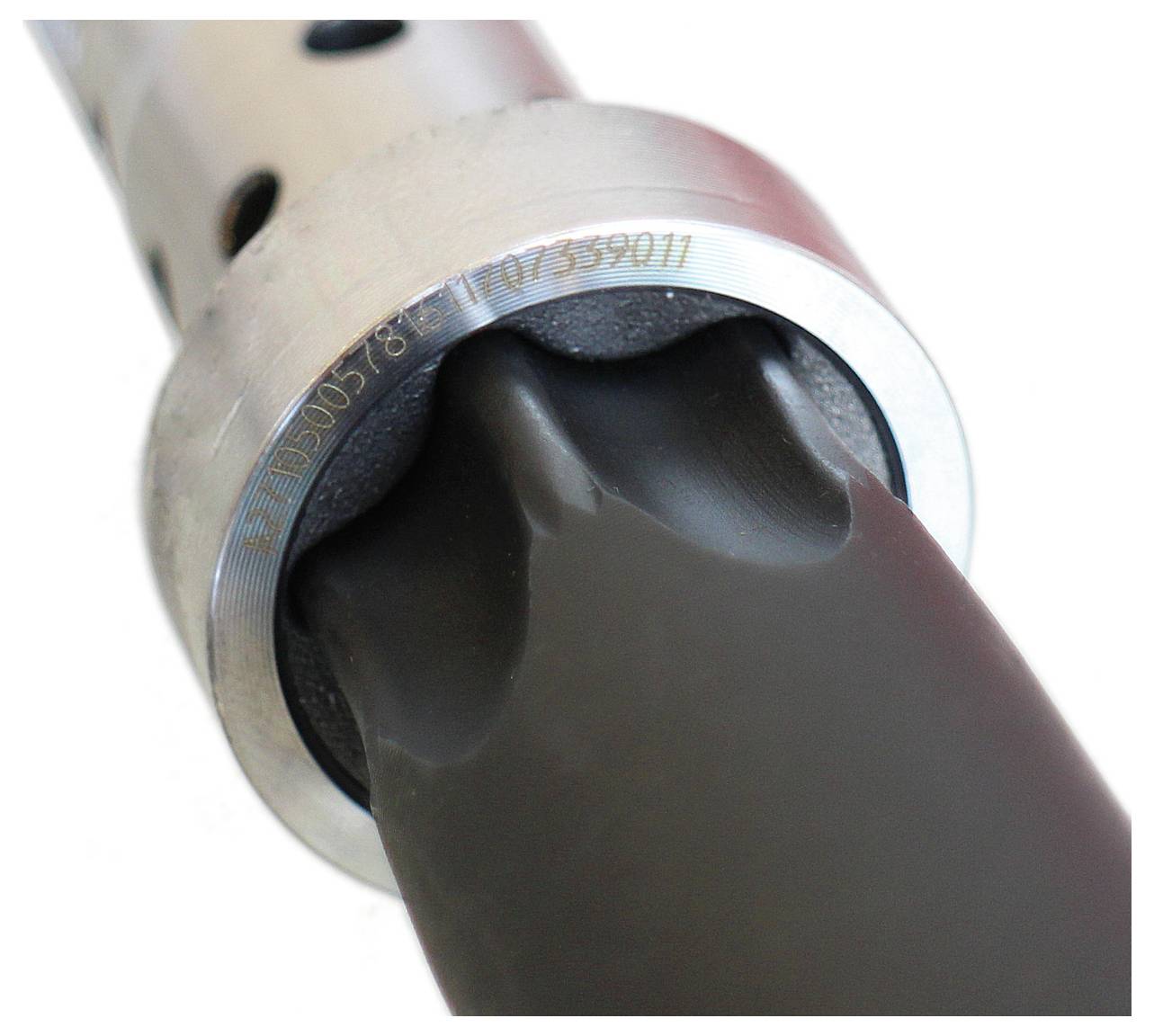 Nahaufnahme eines metallischen zylindrischen Objekts mit einem schwarzen Gummielement, möglicherweise Teil einer mechanischen oder Automobilkomponente.