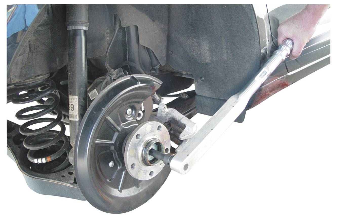 Eine Person verwendet ein Werkzeug, um die Radnabenbaugruppe eines Autos anzupassen und zeigt dabei einen Fahrzeugwartungsprozess.