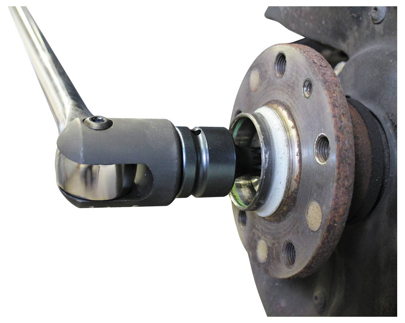 „Eine Nahaufnahme eines Ratschenschlüssels, der verwendet wird, um eine Schraube an einer rostigem Radnabe festzuziehen, Teil einer Fahrzeugwartungsaufgabe.