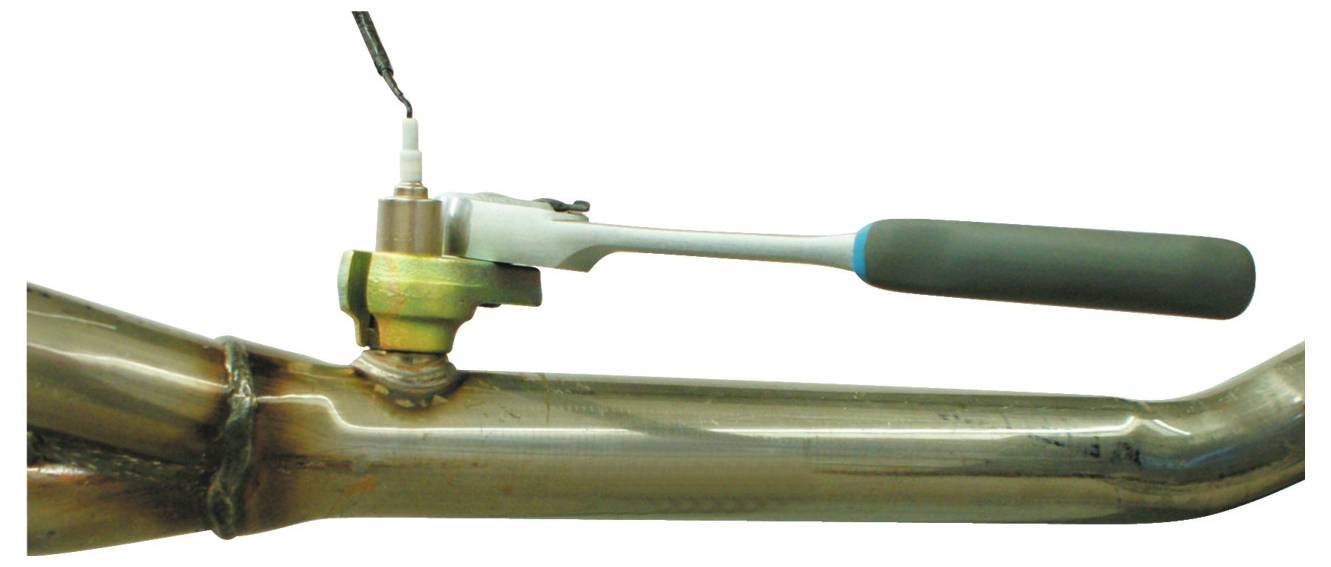 Ein Steckschlüssel ist mit einem Sensor an einem Metallrohr verbunden, wahrscheinlich zum Anziehen oder Lockern des Sensors in einer mechanischen Umgebung.